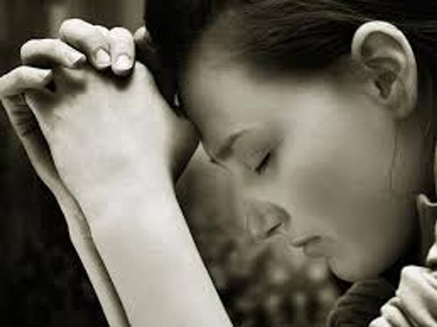 Praying Hands 桌布 壁紙 — 一個女人閉上眼睛，將頭靠在緊握的雙手上，以單色特寫鏡頭拍攝。