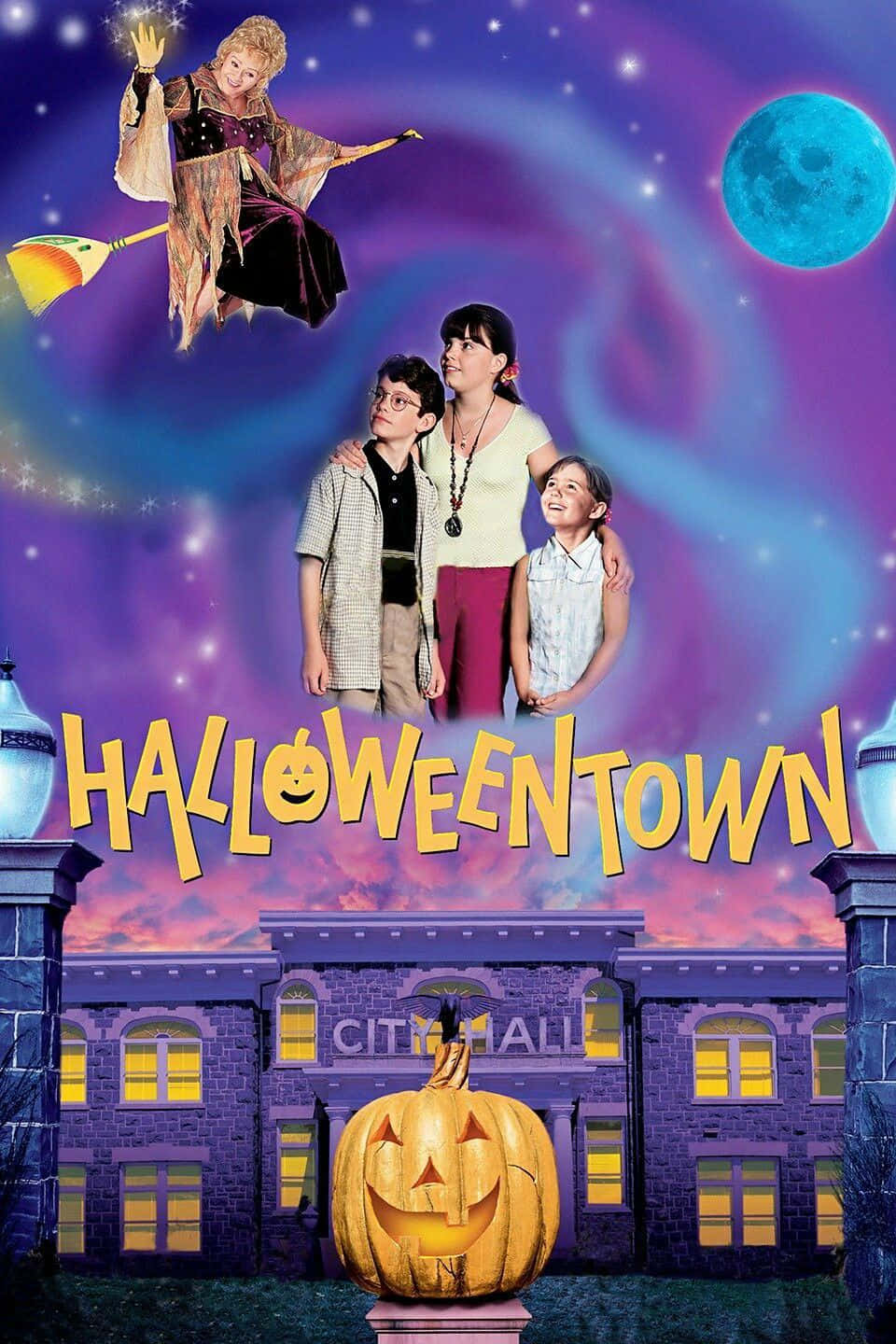 Halloweentown 桌布 壁紙 — 一個女巫騎著掃帚飛過三個站在市政廳前發光南瓜燈前的孩子，背景是星空紫色天空和藍月亮。