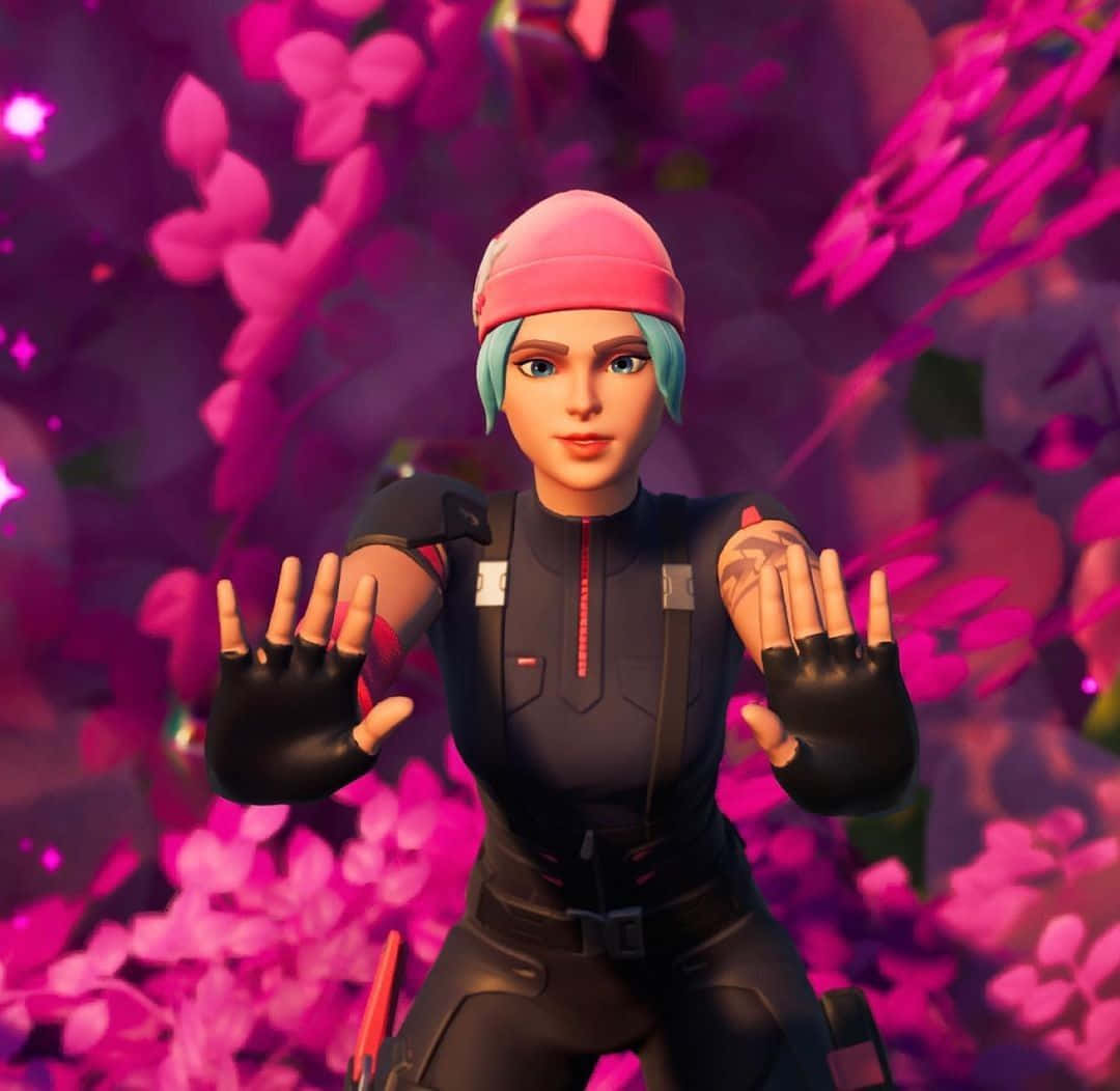 遊戲 桌布 壁紙 — 一個女性Fortnite角色身穿黑色戰術裝備和粉紅色毛帽，雙手伸展，站在充滿活力的粉紅色花卉背景前。