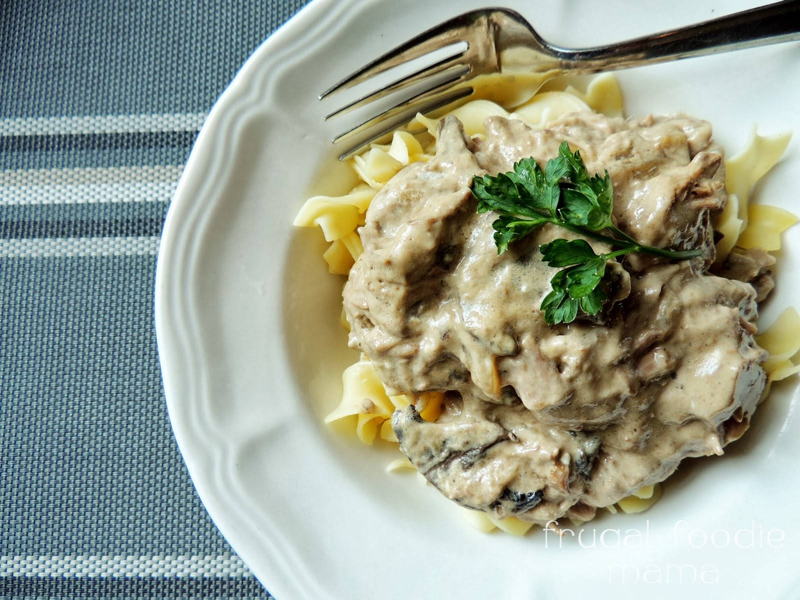 Pasta 桌布 壁紙 — 一個奶油牛肉斯特羅加諾夫配雞蛋麵和新鮮歐芹裝飾，放在白色盤子上。