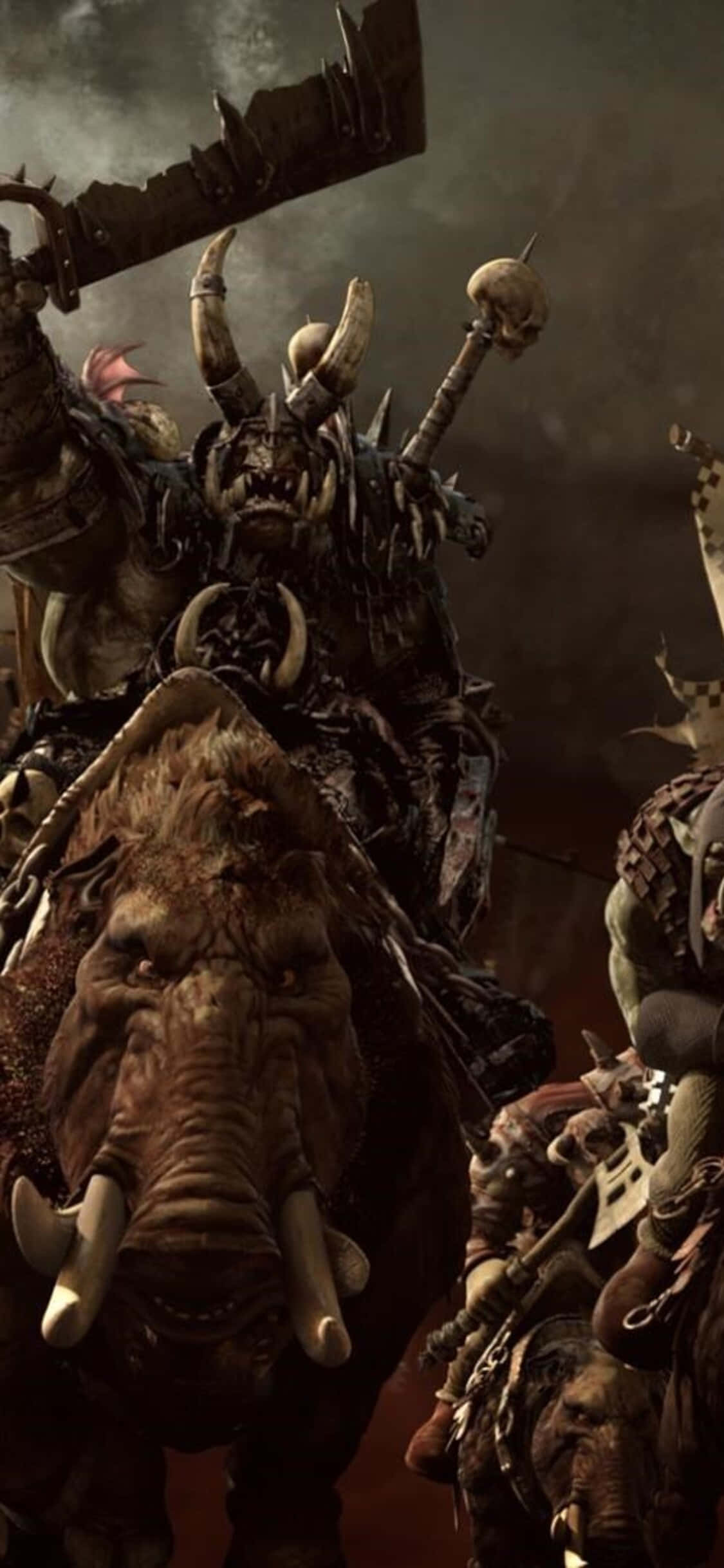 iPhone X Total War Warhammer 桌布 壁紙 — 一個威嚇的獸人 warlord 騎著一頭長牙野豬，在暴風雨的天空下揮舞著帶刺的戰鎚。