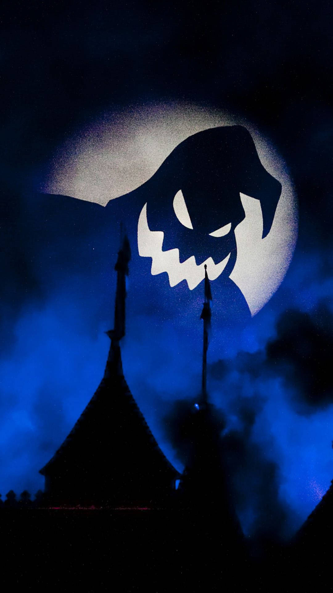 Halloween Phone 桌布 壁紙 — 一個威脅性的傑克南瓜燈面孔在深藍色夜空中閃爍的滿月背景下，籠罩著黑暗城堡的輪廓。