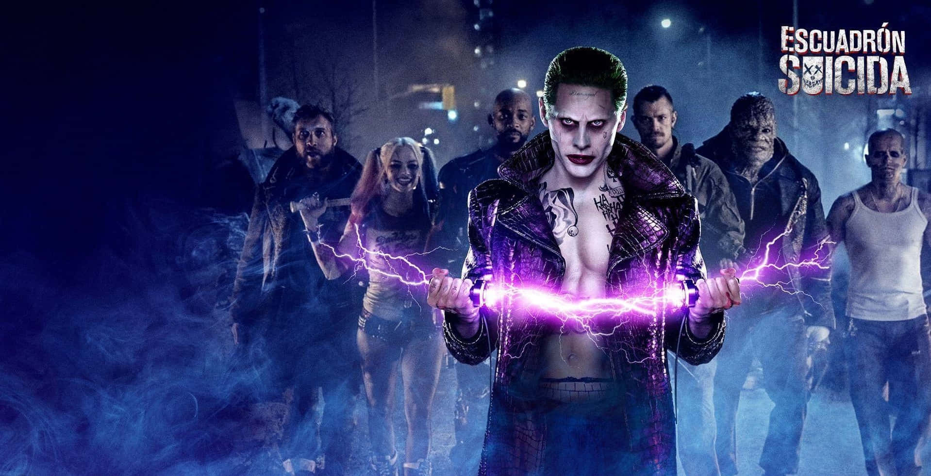 The Suicide Squad 桌布 壁紙 — 一個威脅性的小丑雙手握著噼啪作響的紫色閃電，他的自殺突擊隊幫派在煙霧瀰漫的城市夜晚中隱約出現在他身後。