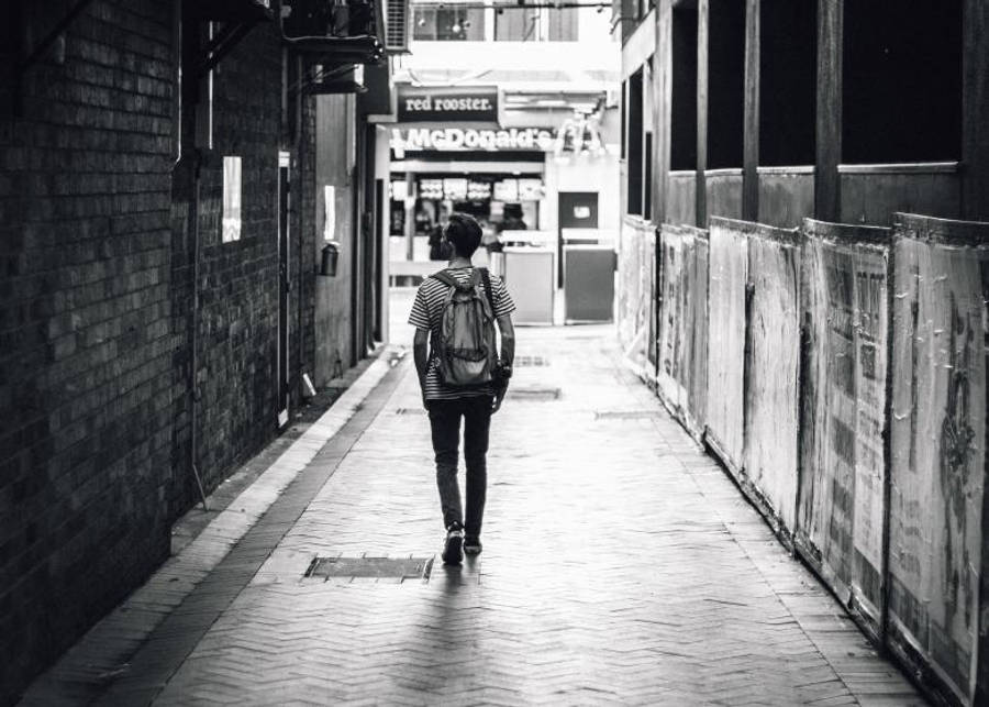 Lonely 桌布 壁紙 — 一個孤獨的人揹著背包，沿著狹窄的城市小巷走向街尾的麥當勞。