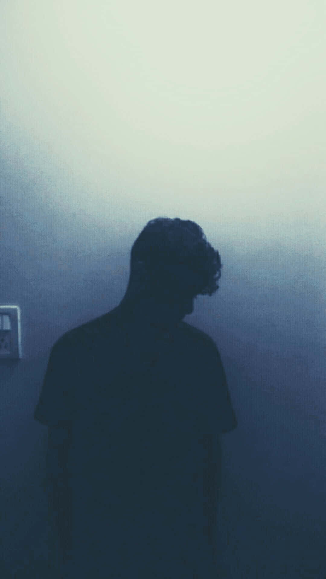 shadow 桌布 壁紙 — 一個孤獨的人的剪影站在昏暗的藍色房間裡，低著頭靜靜沉思。