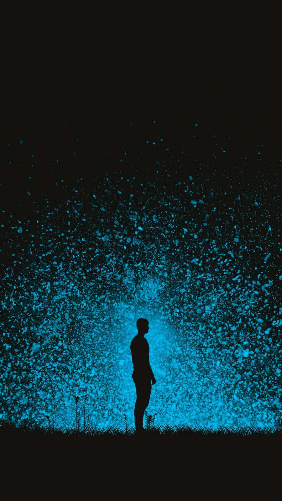 Black And Blue iPhone 桌布 壁紙 — 一個孤獨的人類剪影站在田野中，發光的藍色粒子在黑色天空下向上爆發。
