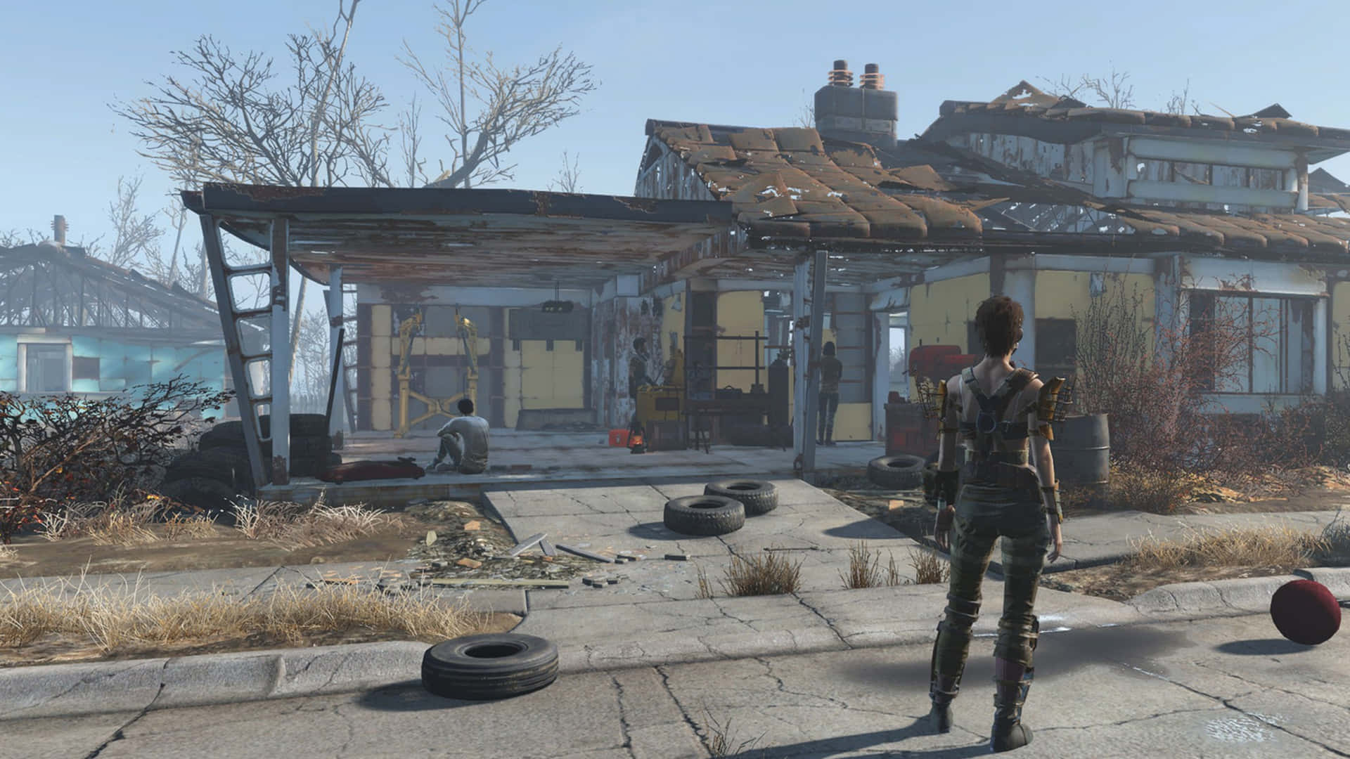 Fallout 4 Wasteland 桌布 壁紙 — 一個孤獨的倖存者穿著末日裝備，站在一間窗戶破損、金屬生鏽的破舊房子前，背景是晴朗的藍天。