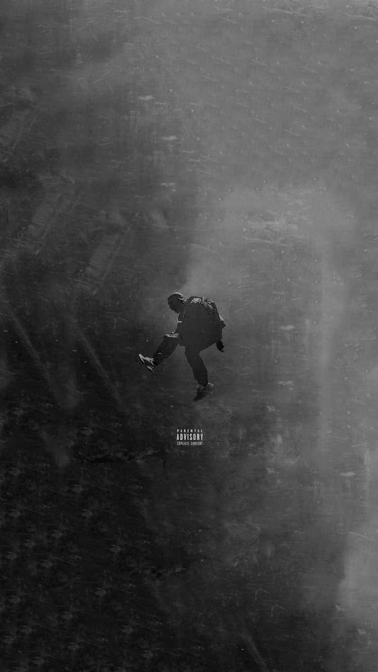 Yeezy 桌布 壁紙 — 一個孤獨的剪影人物穿過霧氣瀰漫、單色的城市峽谷，帶有雨痕和家長指引標誌。