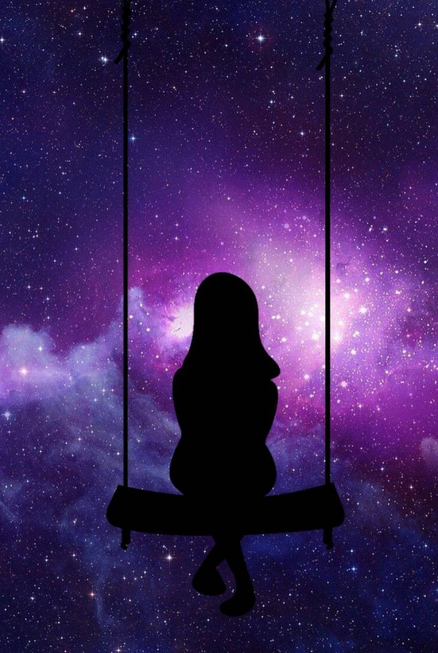 Pretty Galaxy 桌布 壁紙 — 一個孤獨的剪影坐在鞦韆上，懸掛在充滿活力的紫色和藍色星空銀河背景前。