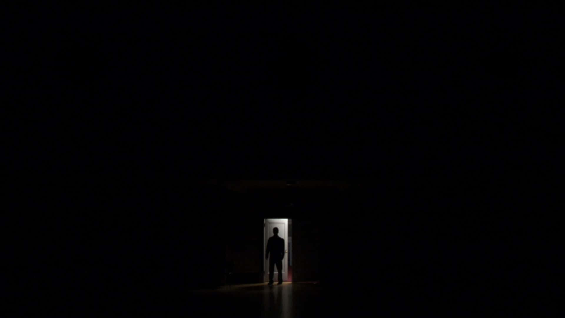 Dark Room 桌布 壁紙 — 一個孤獨的剪影站在一個光線明亮的門口，被絕對的黑暗框在一個廣闊的空曠空間中。