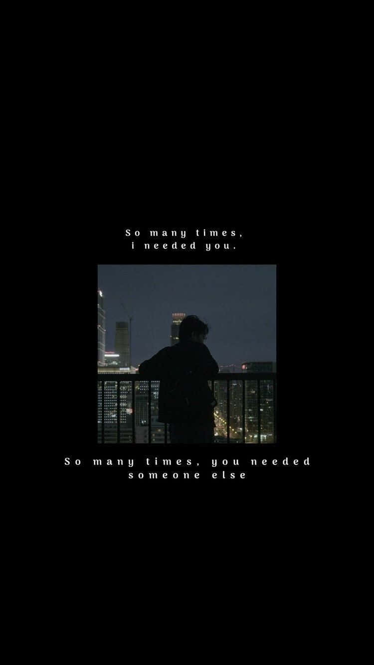Aesthetic Dark 桌布 壁紙 — 一個孤獨的剪影站在陽台上，俯瞰夜晚閃爍的城市景觀，帶有令人心酸的文字疊加。