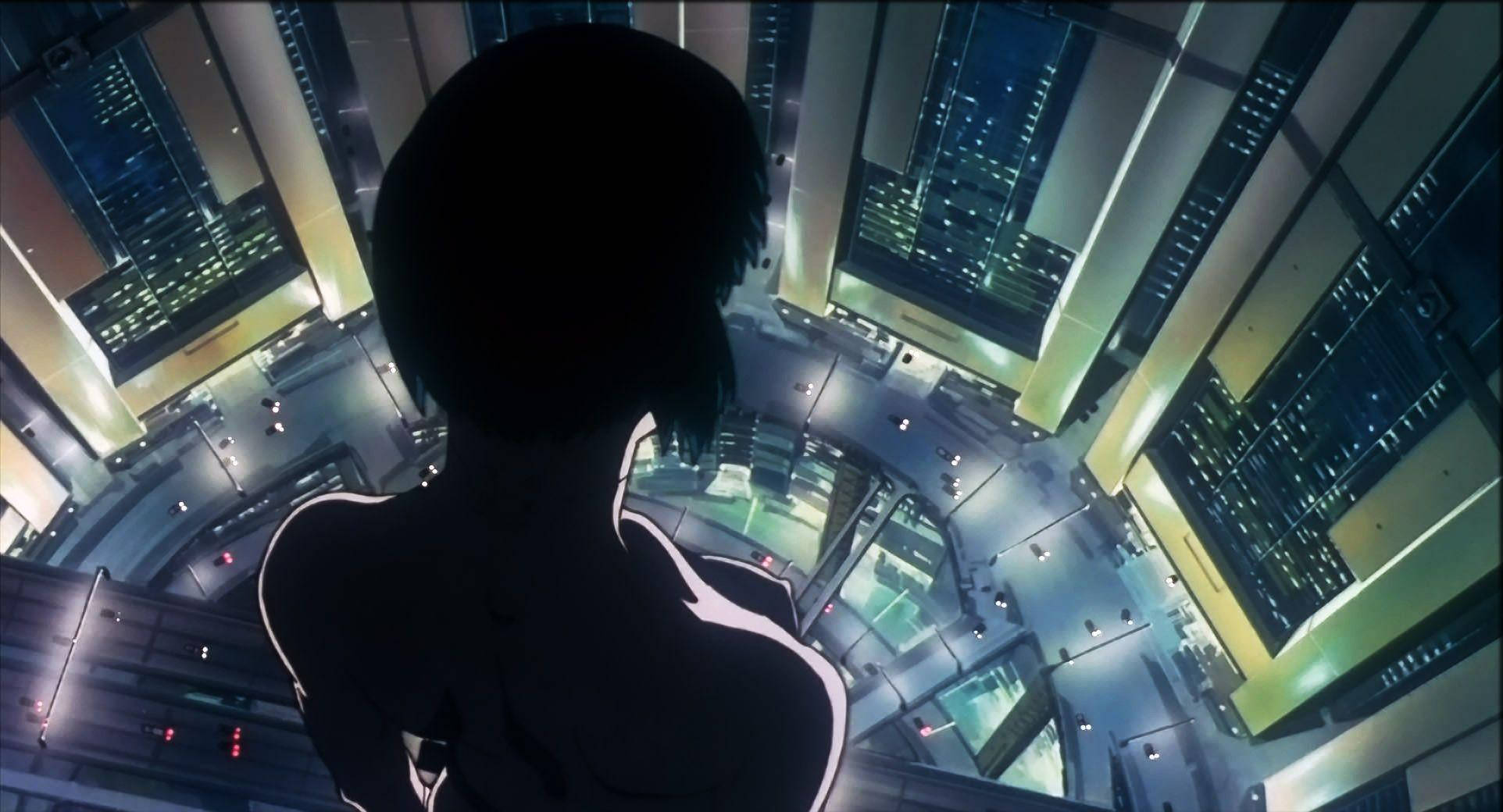 Ghost In The Shell 桌布 壁紙 — 一個孤獨的動漫人物站在摩天大樓頂上，俯瞰夜晚霓虹燈閃爍的城市景觀。