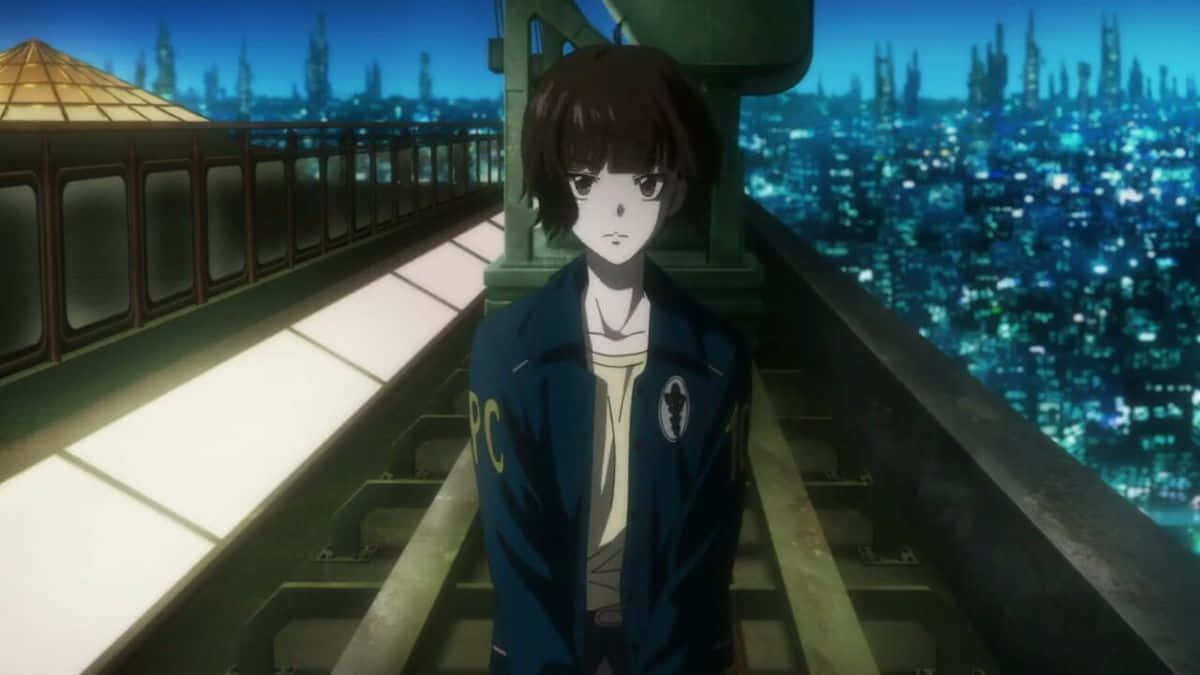 Akane Tsunemori 桌布 壁紙 — 一個孤獨的動漫少年穿著藍色外套站在屋頂上，俯瞰夜晚閃爍的未來城市景觀。