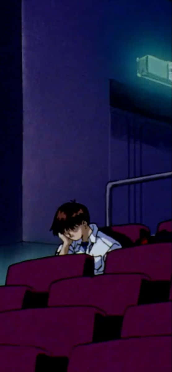 Shinji Ikari 桌布 壁紙 — 一個孤獨的動漫男孩在昏暗的劇院裡，紫色座位和藍色環境燈光下，將頭靠在手上。