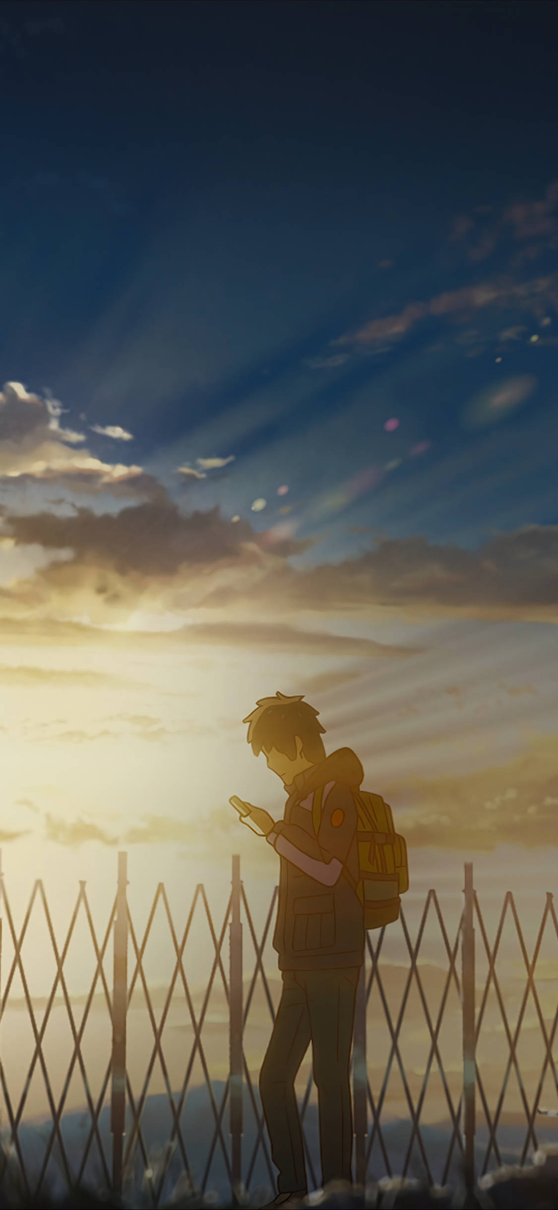 Sad Anime Phone 桌布 壁紙 — 一個孤獨的動漫男孩背著背包站在夕陽下的籬笆旁，沐浴在穿透雲層的金色光芒中。