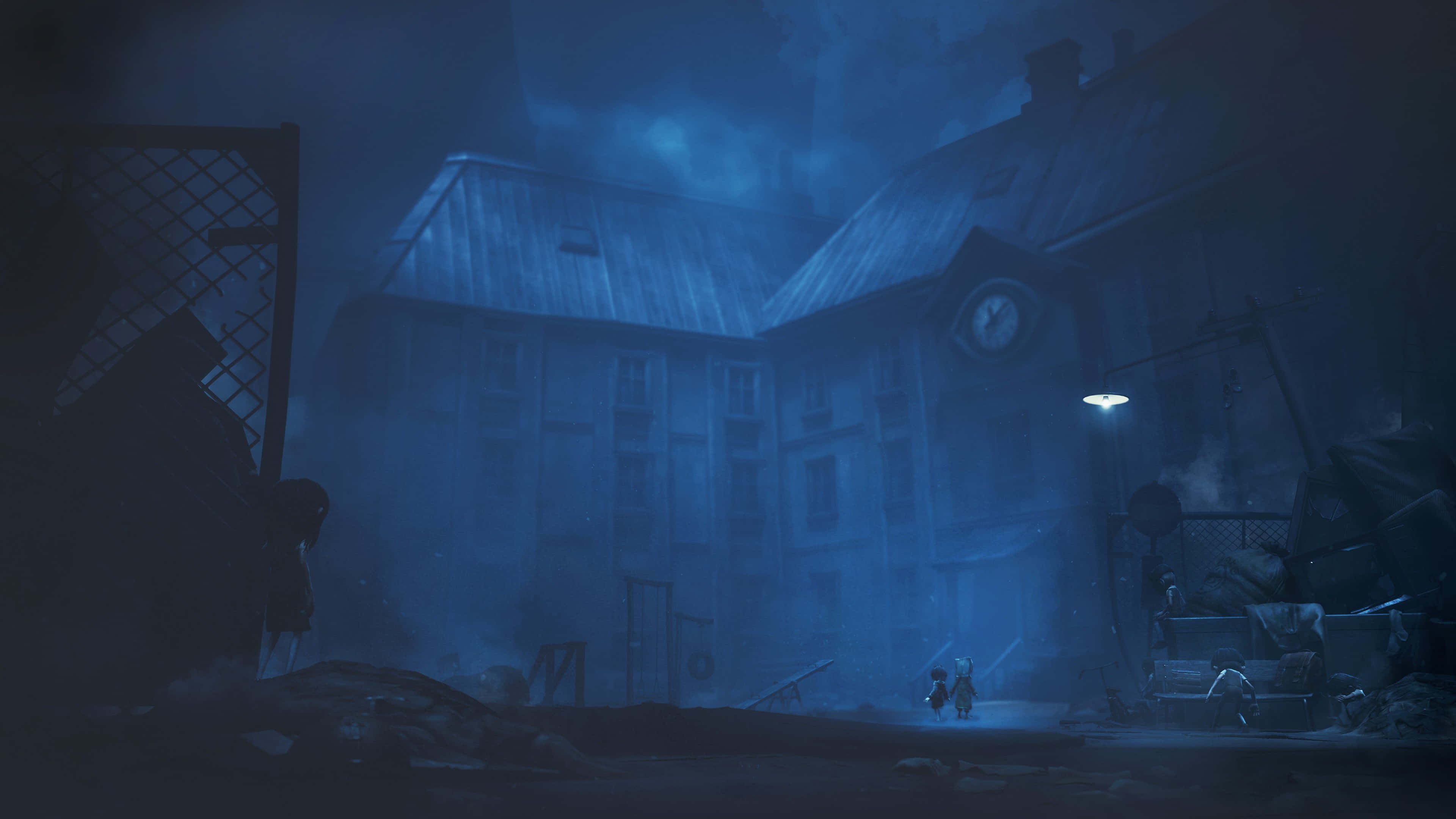 Little Nightmares 4K 桌布 壁紙 — 一個孤獨的孩子在夜晚的藍色調霧氣瀰漫的廢棄小鎮中，在一盞路燈下行走。