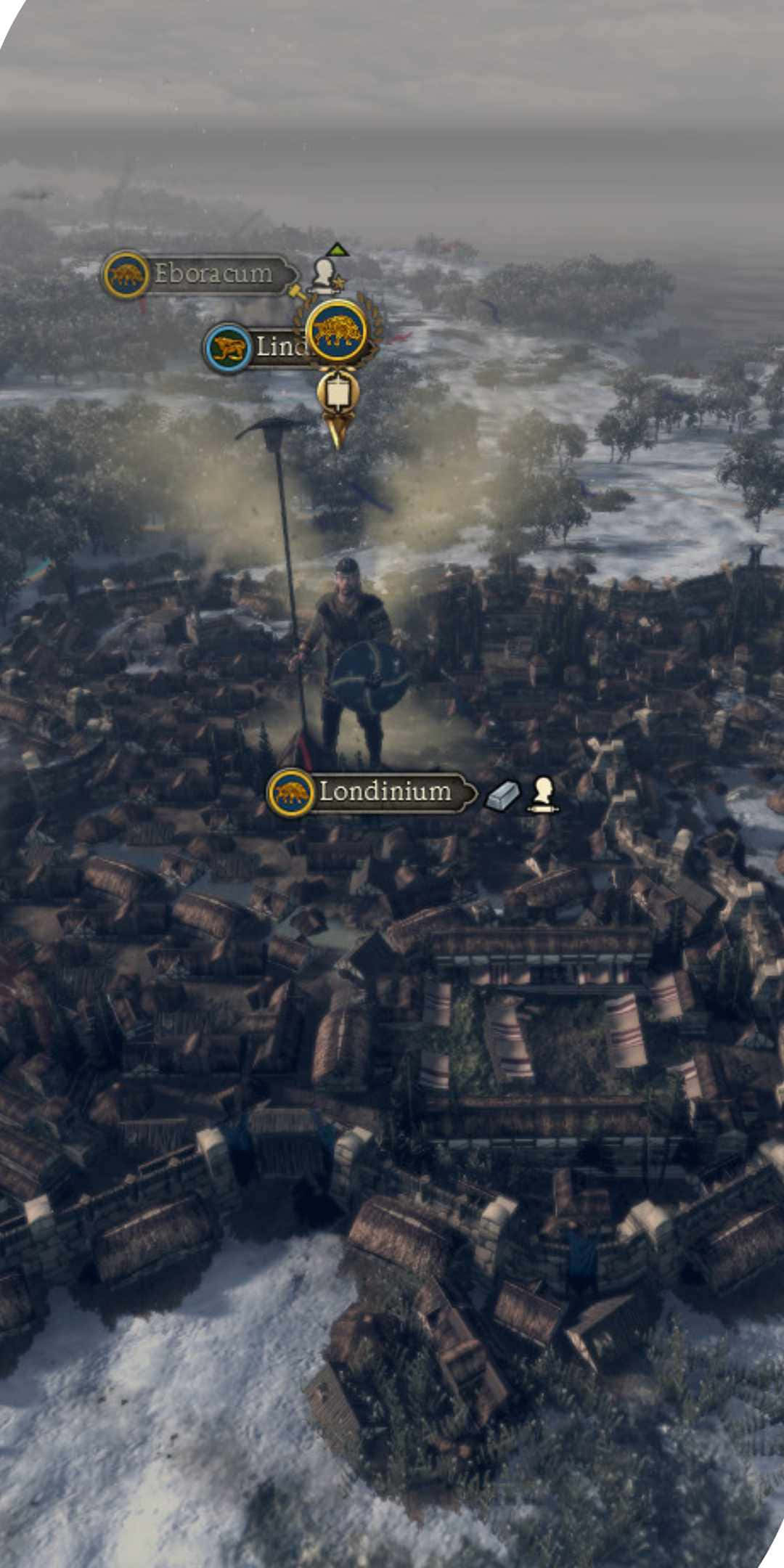 Pixel 3 Total War Attila 桌布 壁紙 — 一個孤獨的戰士站在白雪覆蓋的廢墟上，俯瞰著一個帶有遊戲UI標記的冰凍羅馬定居點。