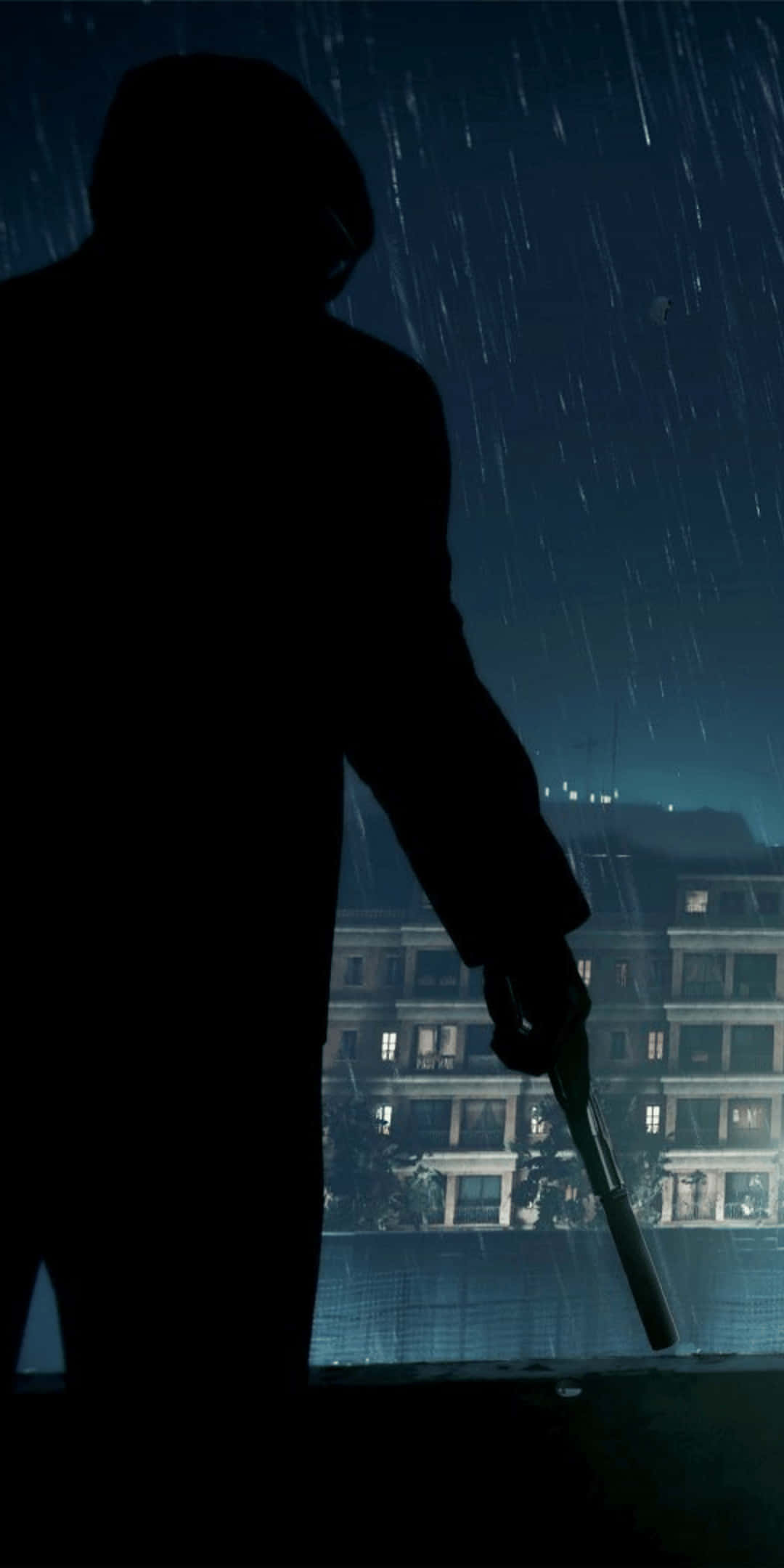 下雨 桌布 壁紙 — 一個孤獨的戴帽人影在夜雨中持槍，俯瞰著窗戶發光的城市景觀。