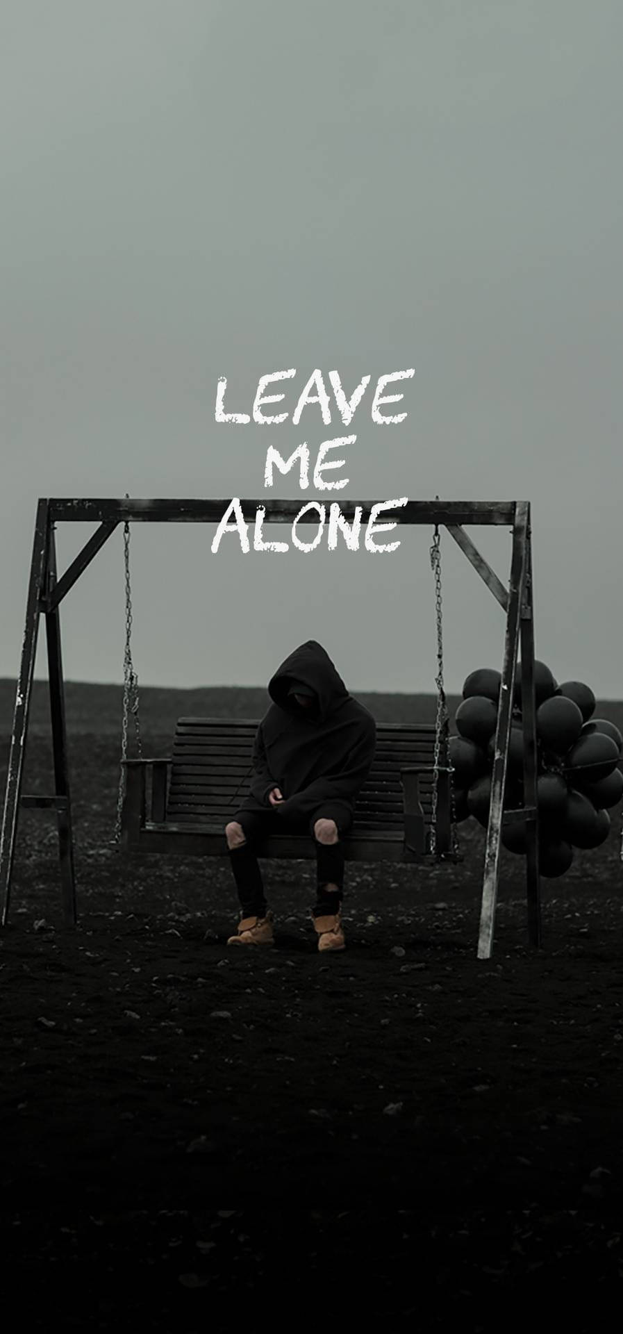 Alone Boy 桌布 壁紙 — 一個孤獨的戴帽人影坐在鞦韆長椅上，灰濛濛的天空上方漂浮著 leave me alone 字樣。