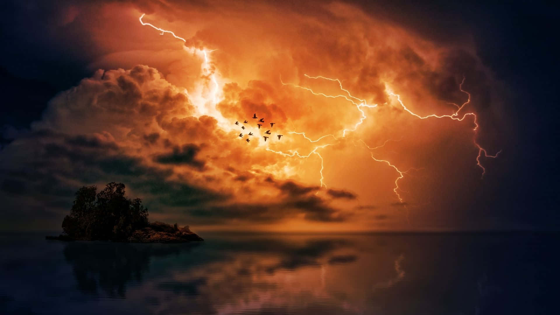 Thunderstorm 桌布 壁紙 — 一個孤獨的樹木覆蓋的島嶼在戲劇性的天空下反射，天空被鮮豔的橙色閃電和飛鳥照亮。