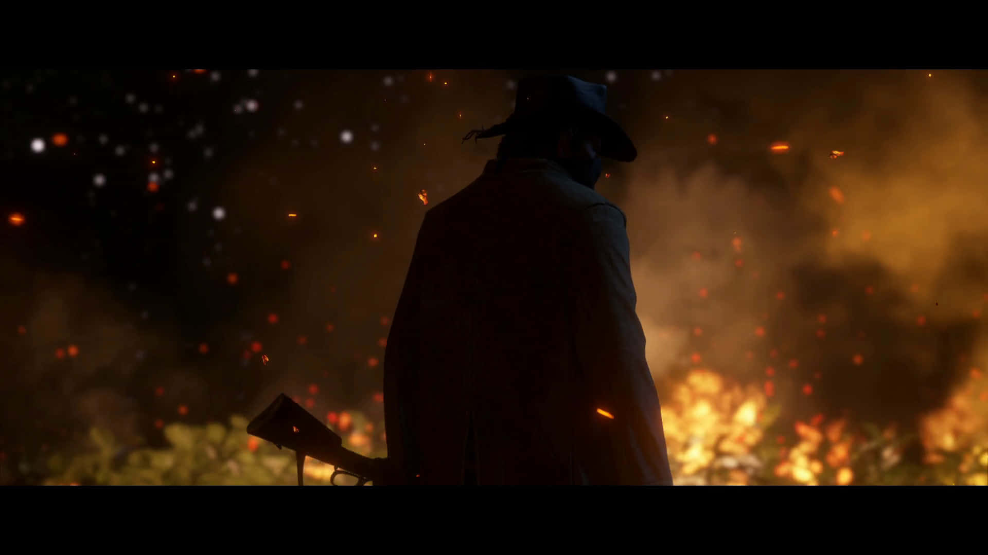 1920x1080 Red Dead Redemption 2 桌布 壁紙 — 一個孤獨的牛仔剪影，在夜晚站在熊熊烈火前，火花在空中飛舞。