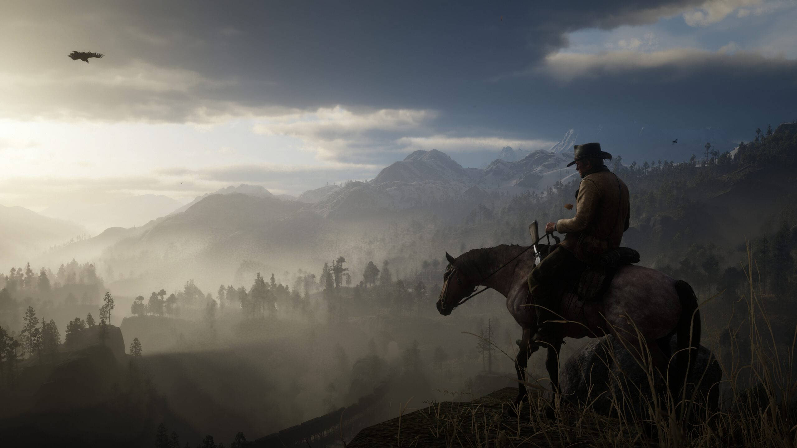 Red Dead Redemption 2 Desktop 桌布 壁紙 — 一個孤獨的牛仔騎在馬背上，俯瞰黎明時分霧氣瀰漫的山谷，頭頂有一隻鳥飛過。