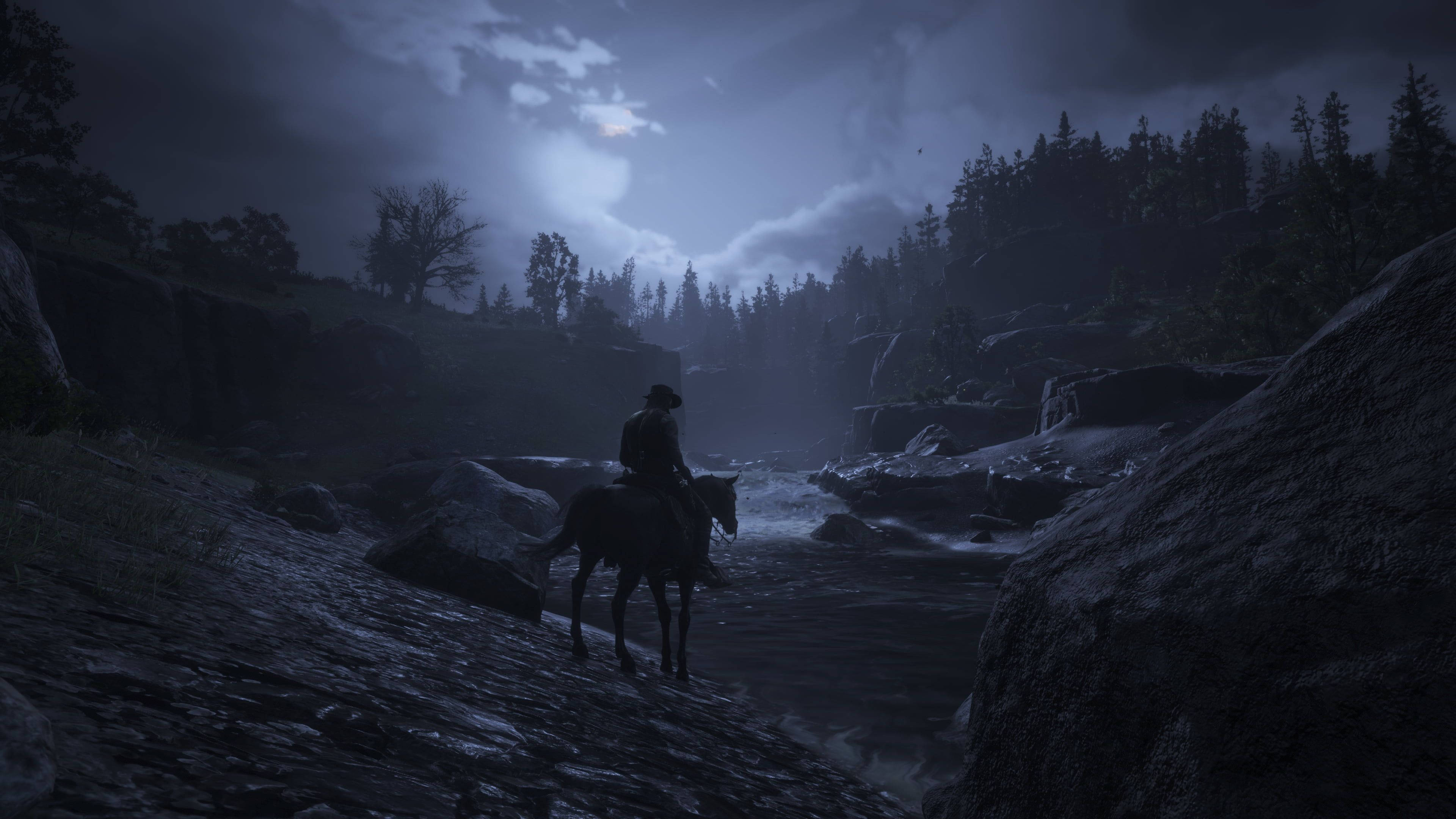 Red Dead Redemption 2 Desktop 桌布 壁紙 — 一個孤獨的牛仔騎著馬，在月光下、黑暗松林環繞的霧氣岩石峽谷中前行。