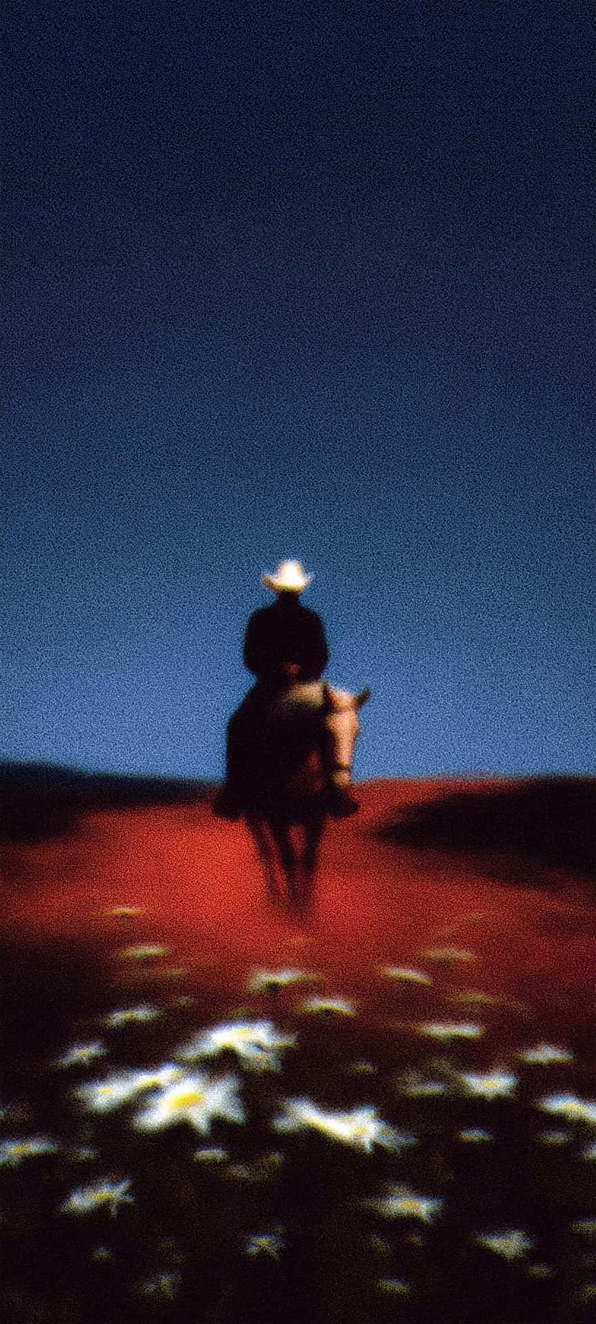 Moody Cowboy Rider Western Desert Cinematic Aesthetic Wallpaper 壁紙 — 一個孤獨的牛仔騎著馬沿著一條發光的紅色小徑穿過白色雛菊田，在深藍色的暮色天空下遠去。
