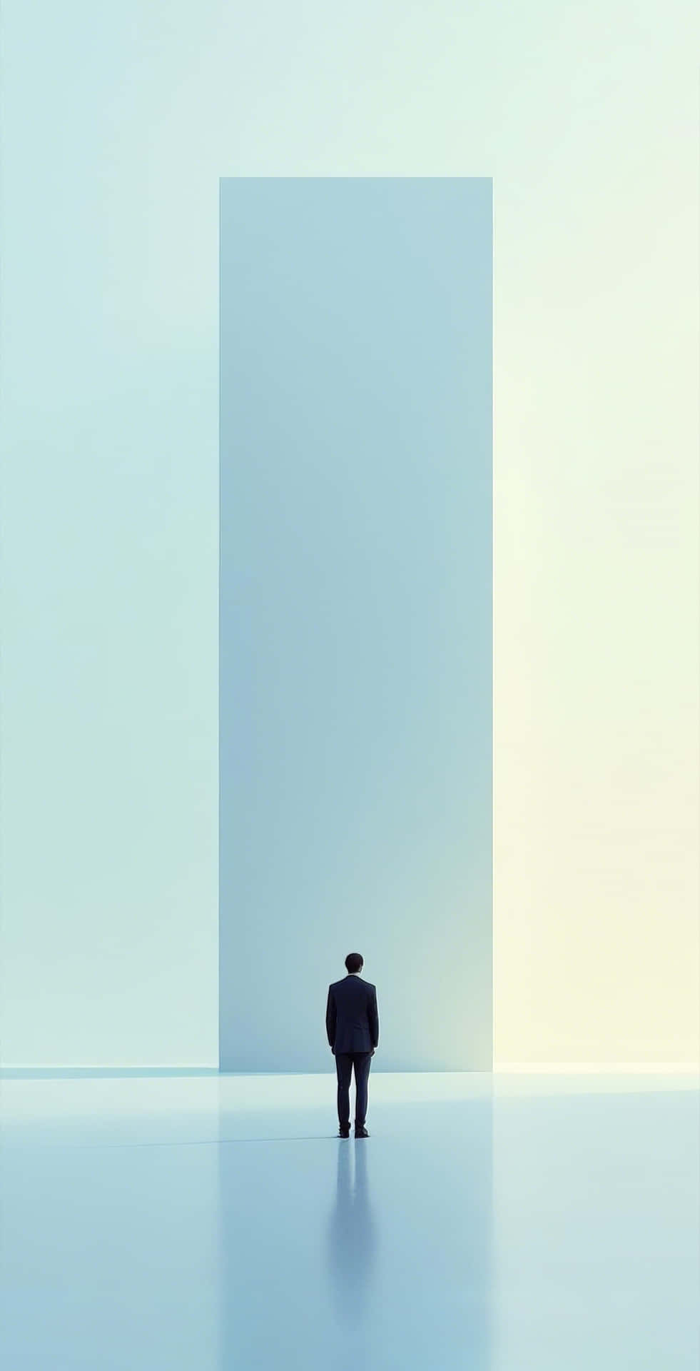 contemplative figure before soft pastel structure 壁紙 — 一個孤獨的男人穿著深色西裝，站在一個廣闊的空曠空間中，面對著一座高聳的極簡藍色巨石，周圍有柔和的漸變燈光。