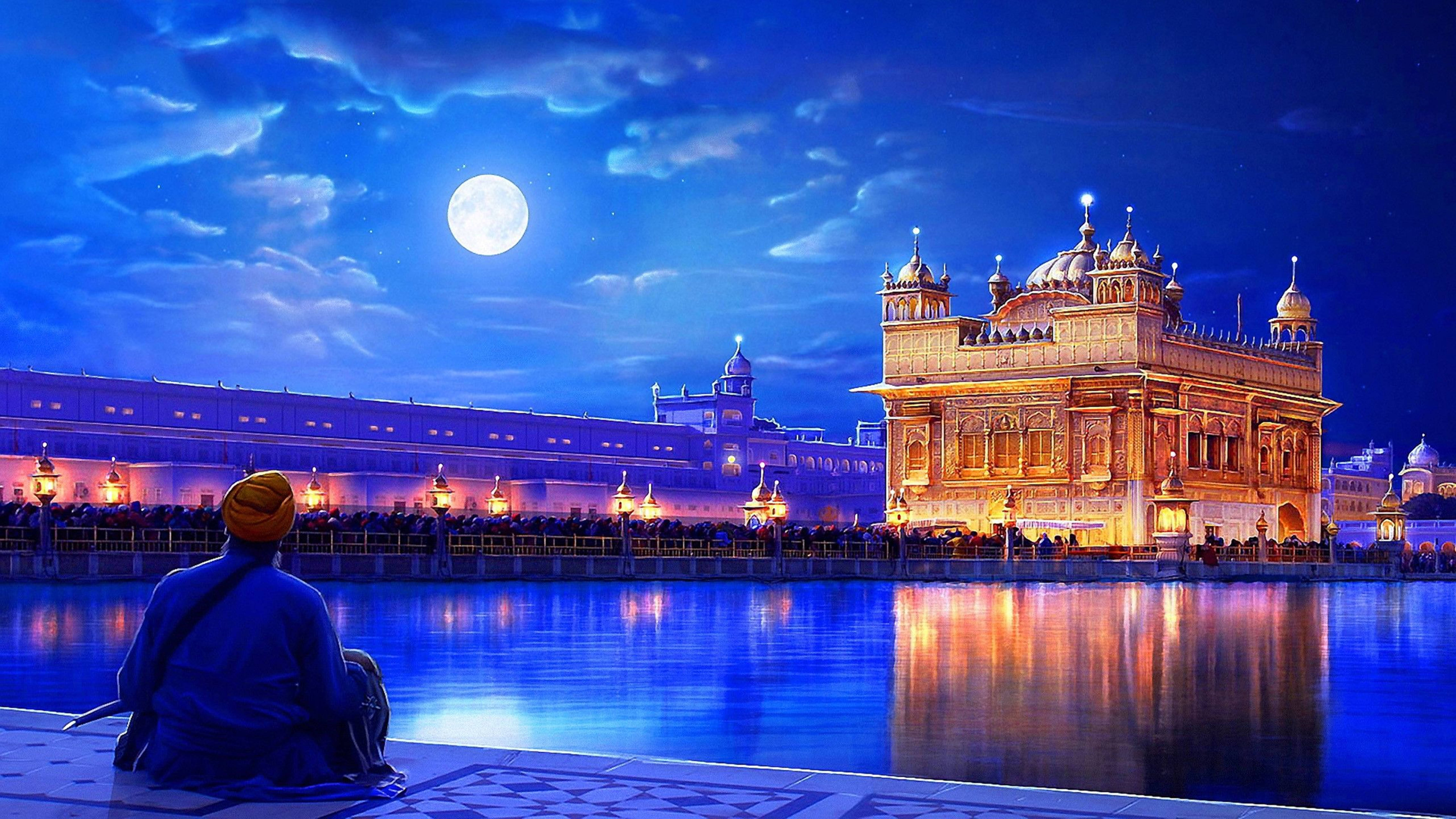 Indian 桌布 壁紙 — 一個孤獨的纏頭巾人物坐在反射池旁，凝視著滿月下被照亮的金廟。