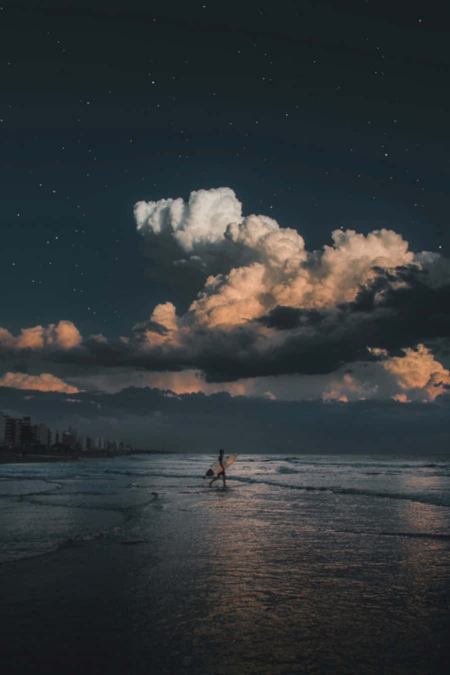 Tumblr 桌布 壁紙 — 一個孤獨的衝浪者在繁星點點的夜空下，頂著發光的雲朵走進海洋。