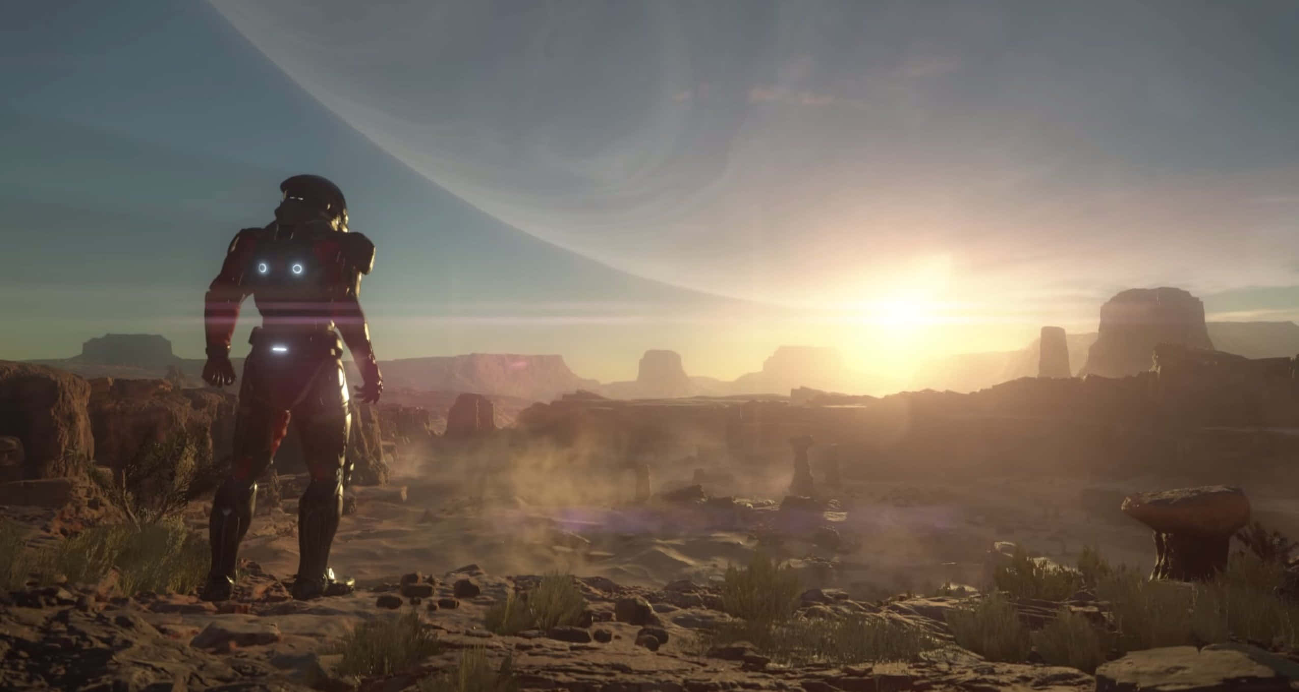 Mass Effect Andromeda 桌布 壁紙 — 一個孤獨的裝甲人物站在塵土飛揚的外星峽谷中，一顆巨大的行星在金色日出時分懸掛在頭頂。