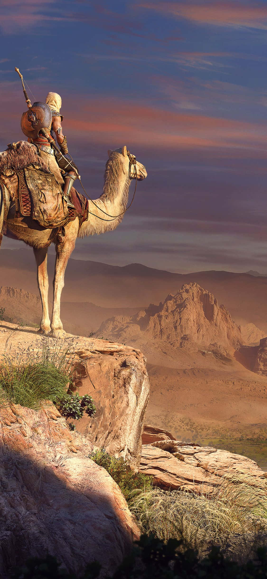 iPhone X Assassin's Creed Origins 桌布 壁紙 — 一個孤獨的裝甲戰士騎著駱駝，站在岩石沙漠懸崖上，俯瞰黃昏天空下的廣闊沙丘。