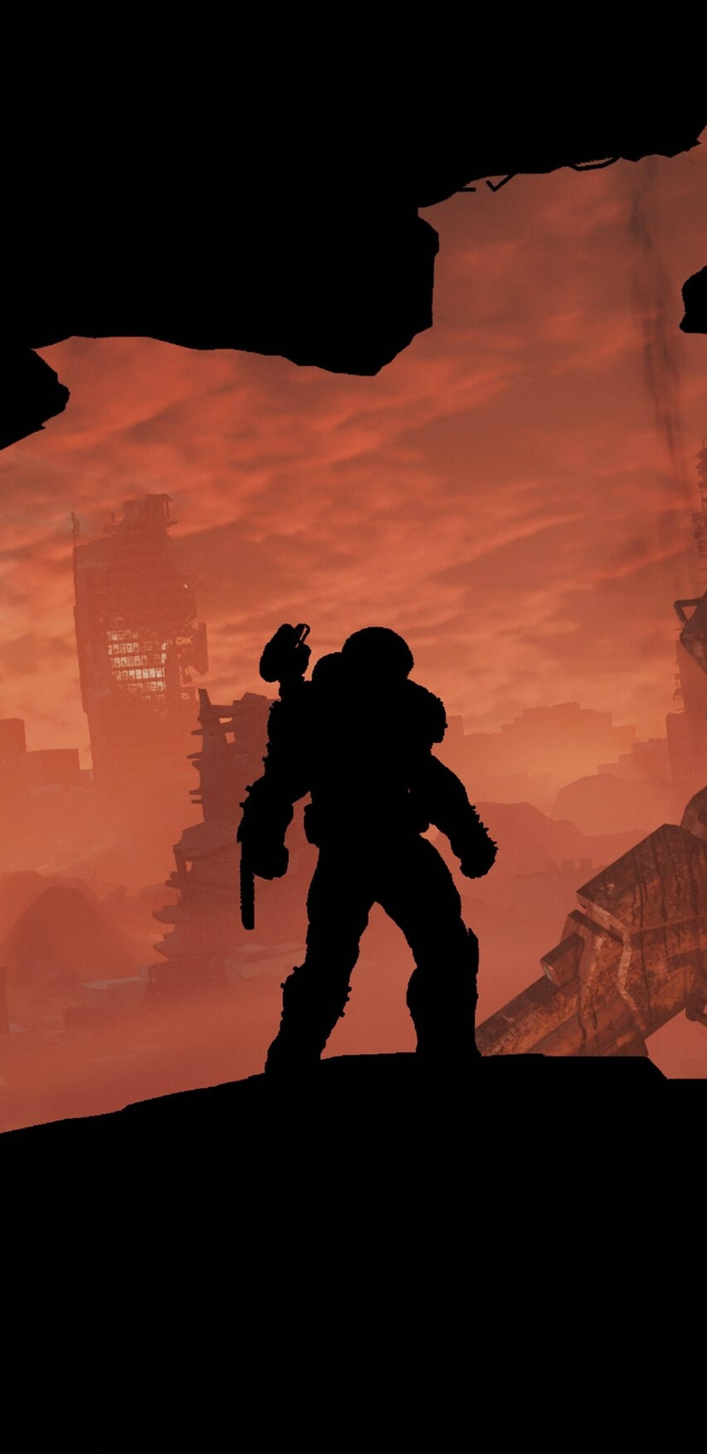 Doom Slayer 桌布 壁紙 — 一個孤獨的裝甲身影站在廢墟上，以剪影形式映襯著火紅的橙色日落天空。