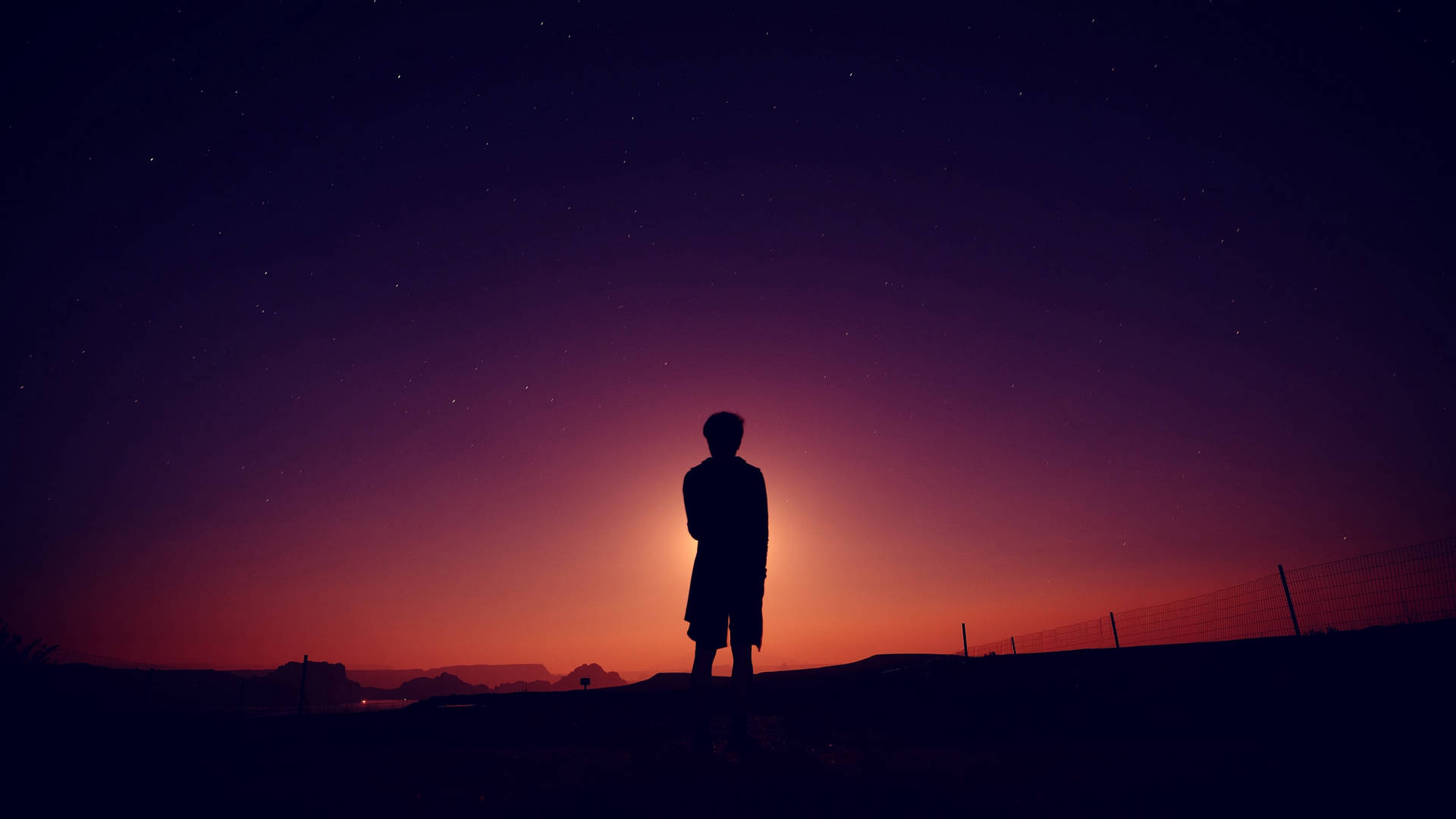 一個人在暮色中獨自站在星空下