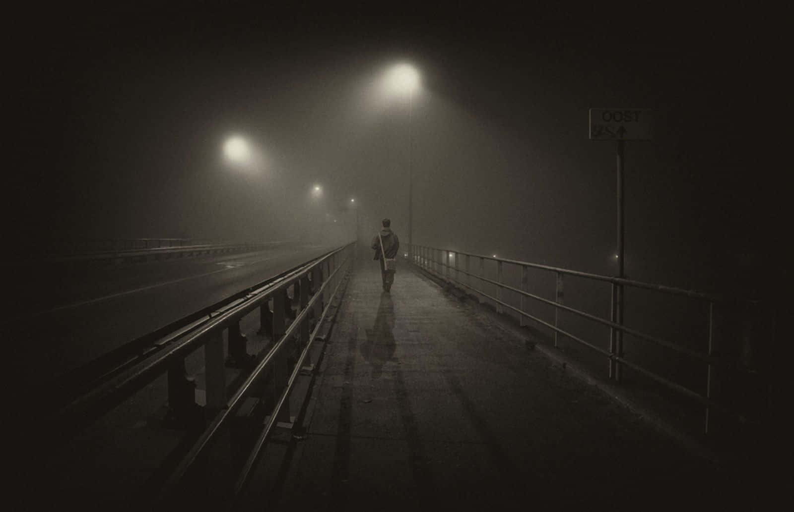 bridge 桌布 壁紙 — 一個孤獨的身影在夜晚的霧橋上獨自行走，發光的街燈投下長長的影子。