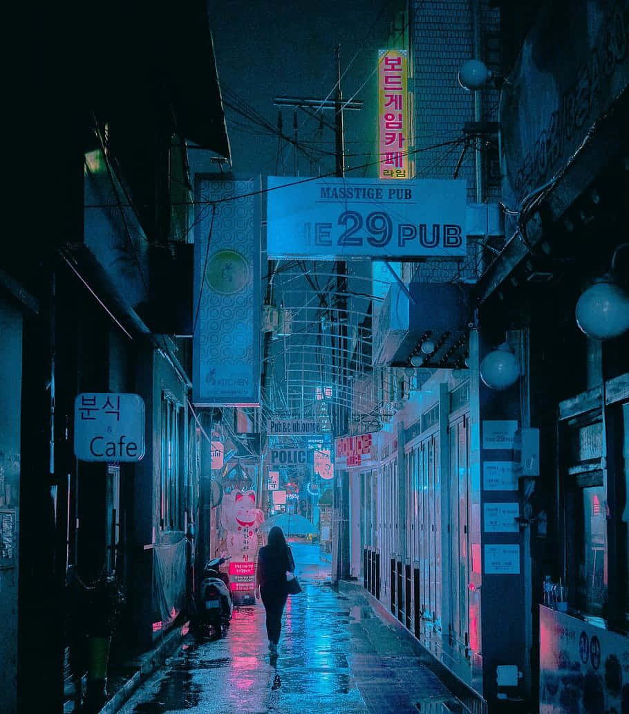 藍色美學 桌布 壁紙 — 一個孤獨的身影在夜晚走下一條霓虹燈照亮的小巷，在發光的招牌下反射濕漉漉的人行道。