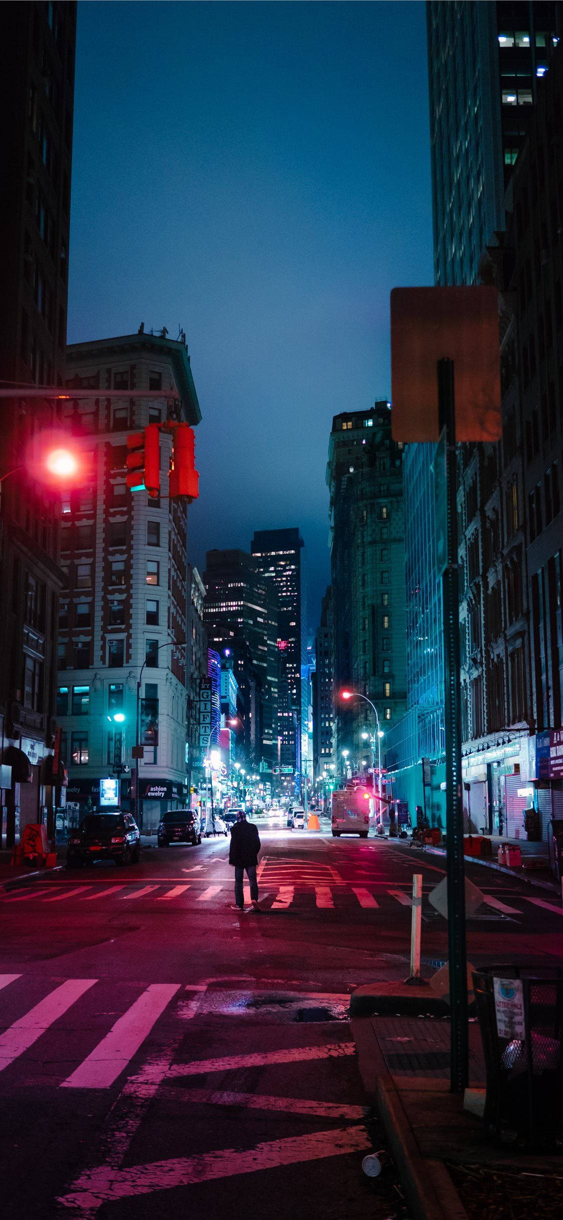 New York 桌布 壁紙 — 一個孤獨的身影在夜晚走過濕漉漉的城市街道，下方是發光的紅色交通燈和霓虹招牌。