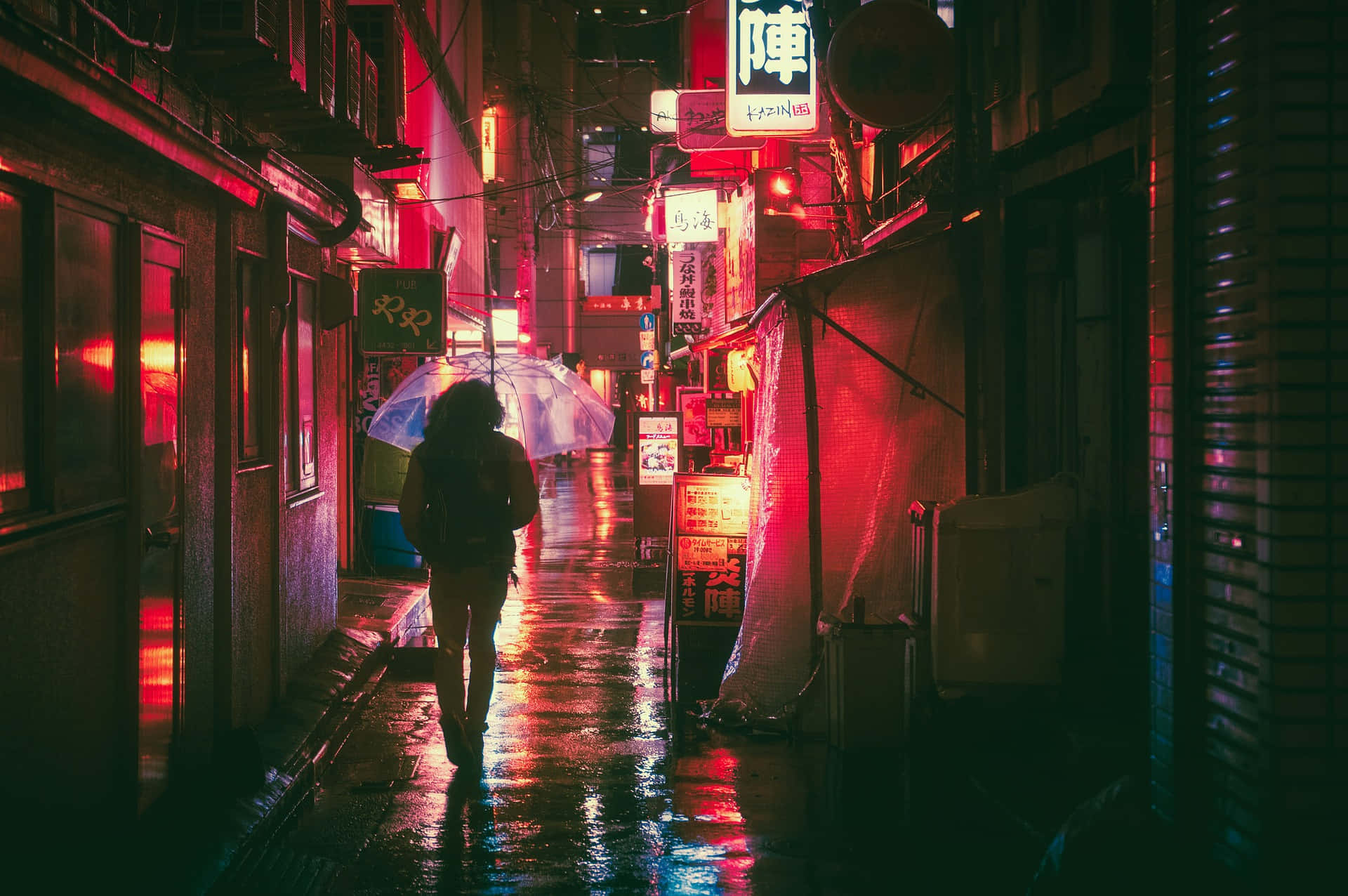 夜晚 桌布 壁紙 — 一個孤獨的身影在夜晚走過被雨水浸濕的霓虹小巷，發光的招牌映照在濕漉漉的人行道上。