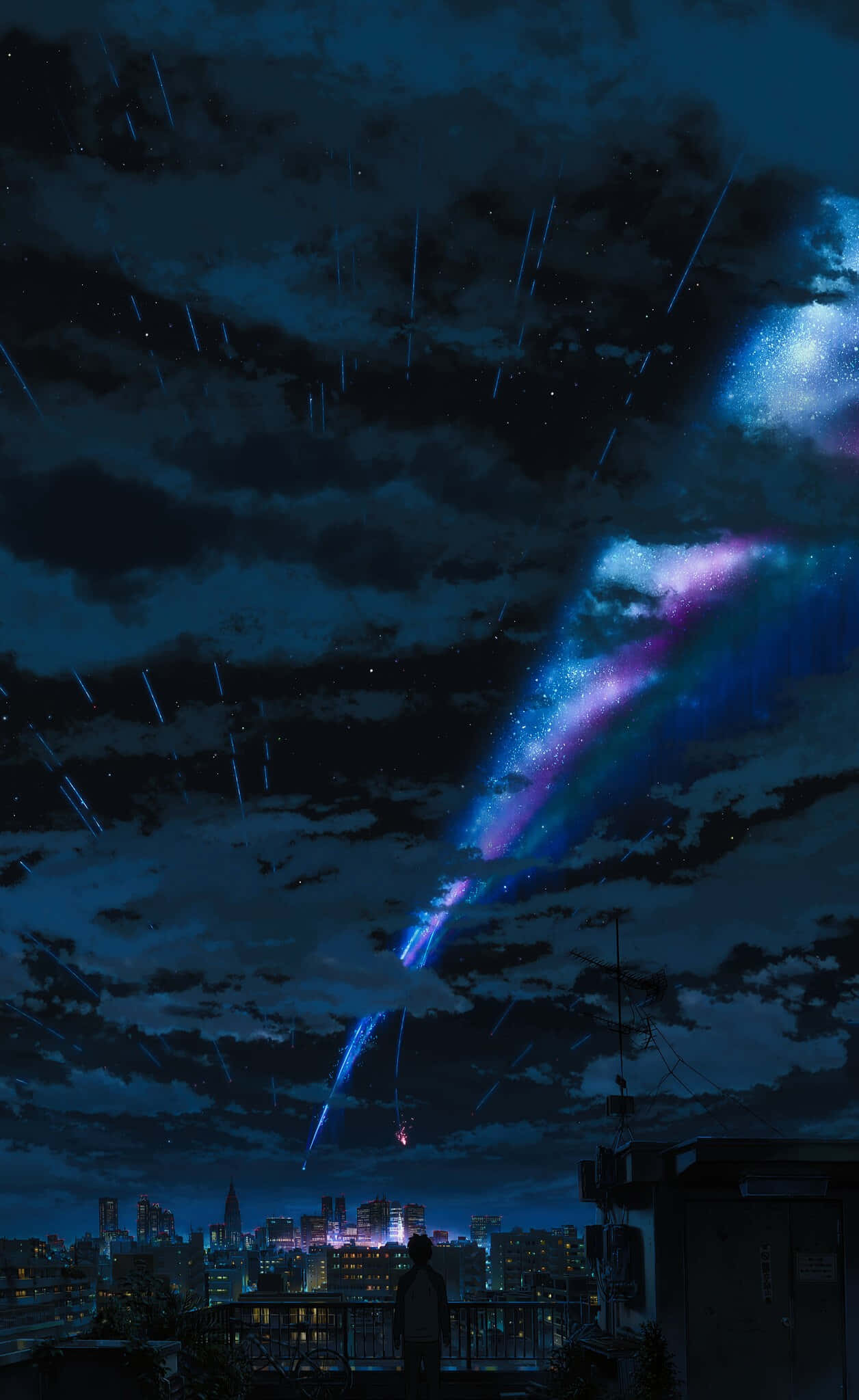 Anime Sky 桌布 壁紙 — 一個孤獨的身影在屋頂上凝視著一場充滿活力的宇宙風暴，紫色和藍色的流星劃過夜間發光的城市景觀。