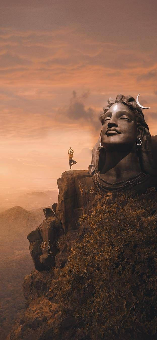 Mahadev Full HD 桌布 壁紙 — 一個孤獨的身影在懸崖頂上冥想，旁邊是一座巨大的寧靜雕像，背景是溫暖的橙色日落天空。