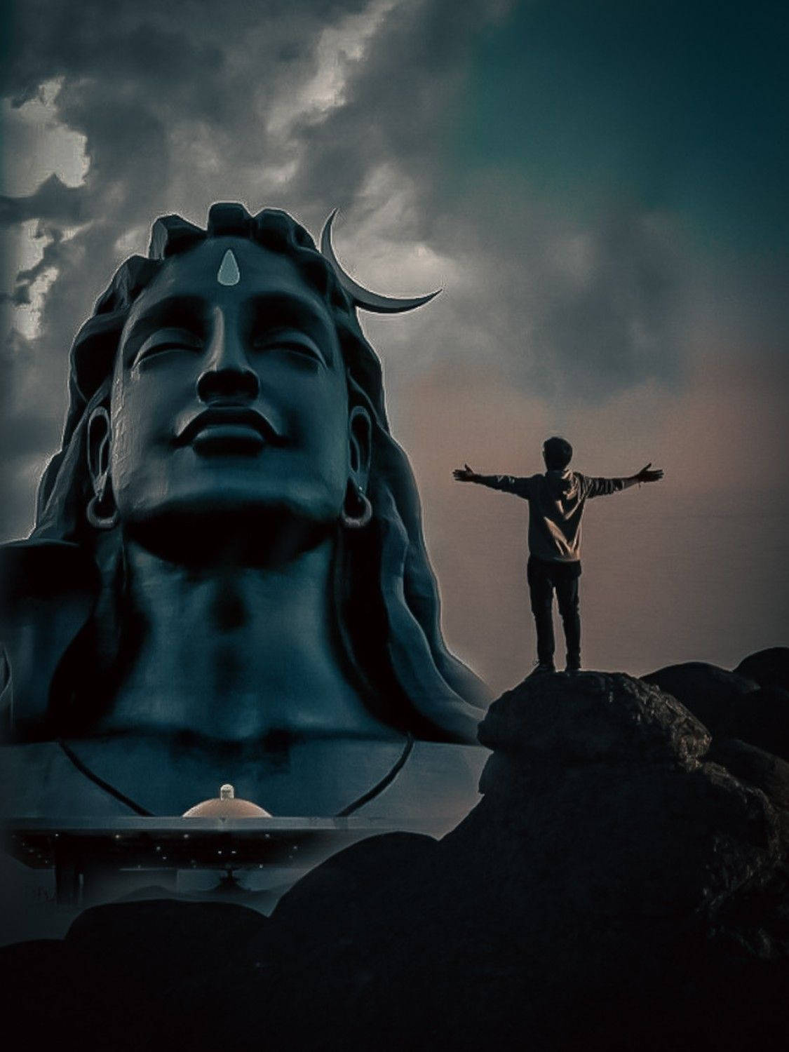 Mahadev Full HD 桌布 壁紙 — 一個孤獨的身影在戲劇性的暴風雨天空下，站在岩石上張開雙臂，面對著巨大的藍色濕婆神像。