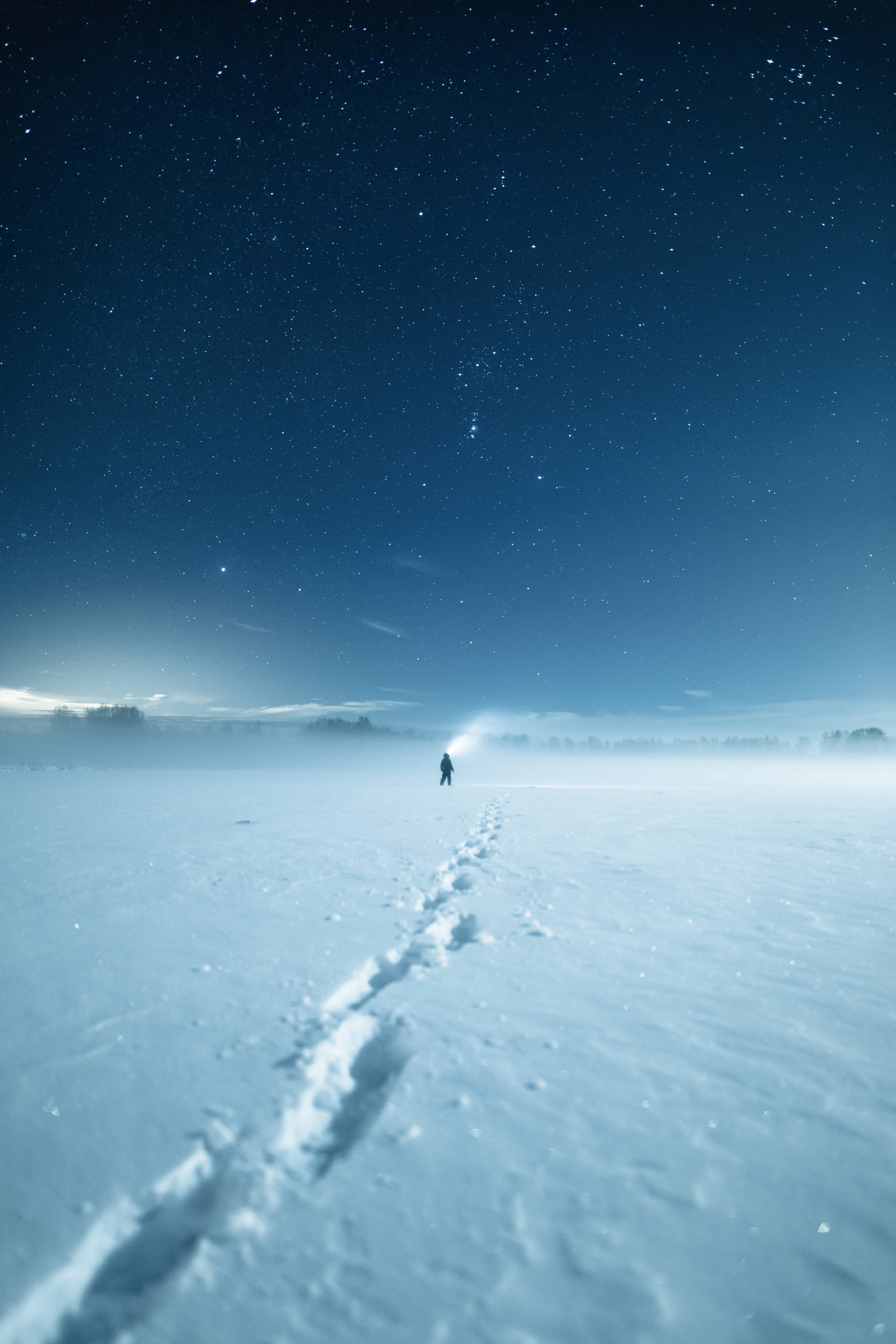 Finland 桌布 壁紙 — 一個孤獨的身影在星空下的雪地中行走，留下腳印。