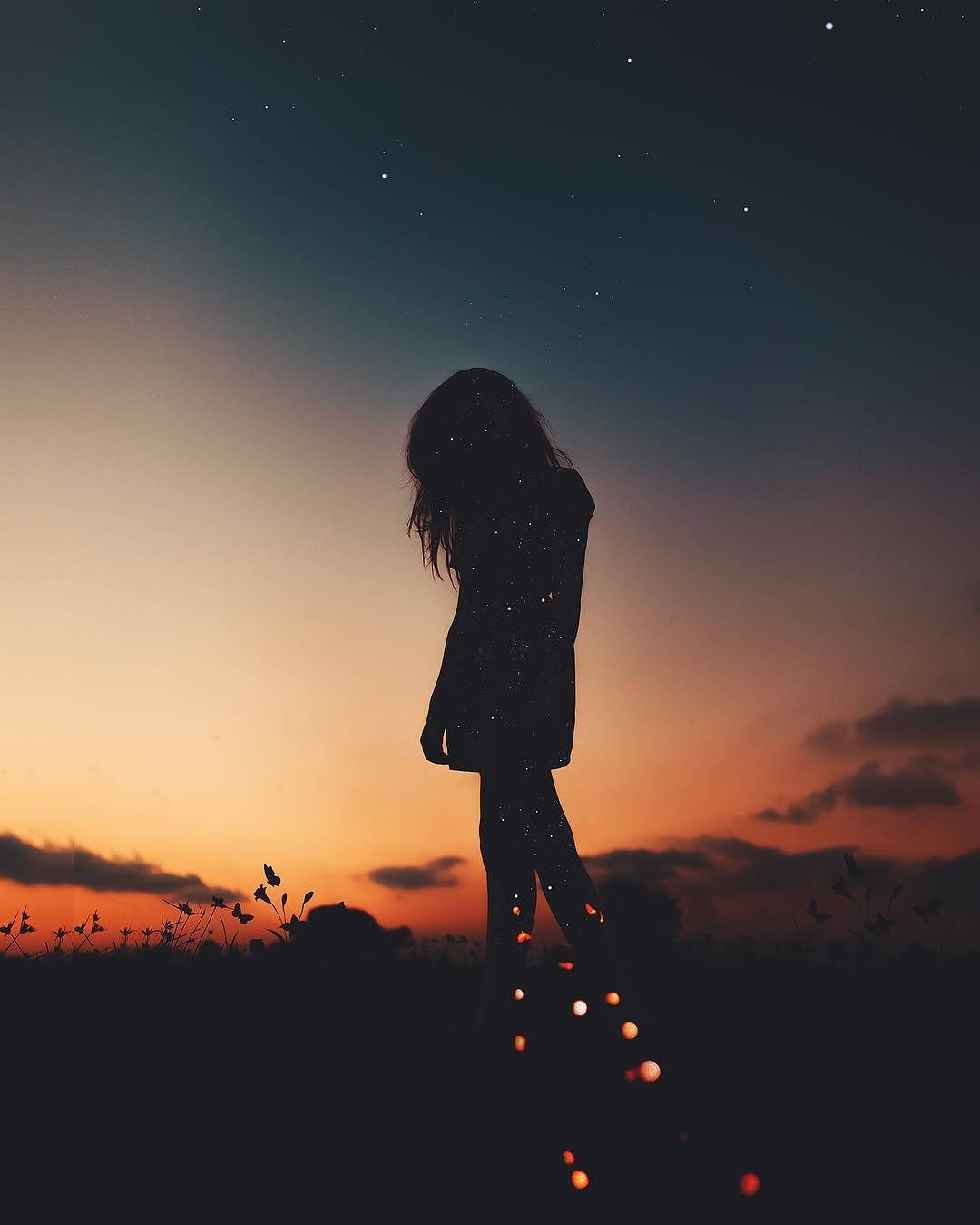 Silhouette 桌布 壁紙 — 一個孤獨的身影在暮色天空的襯托下形成剪影，腳下點綴著星星和發光的球體。