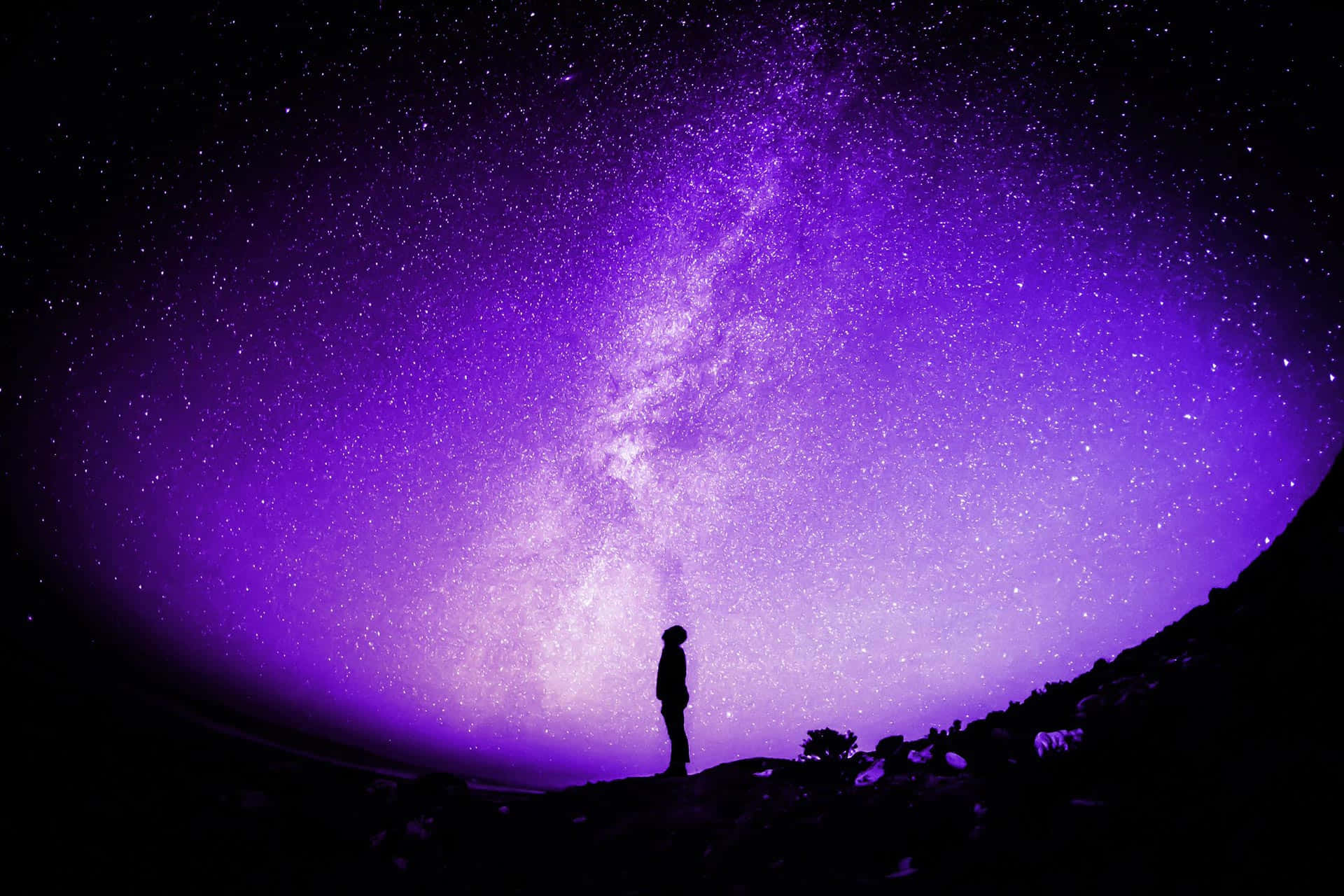 太空 桌布 壁紙 — 一個孤獨的身影在橫跨繁星夜空、充滿活力的紫色銀河下敬畏地站立。