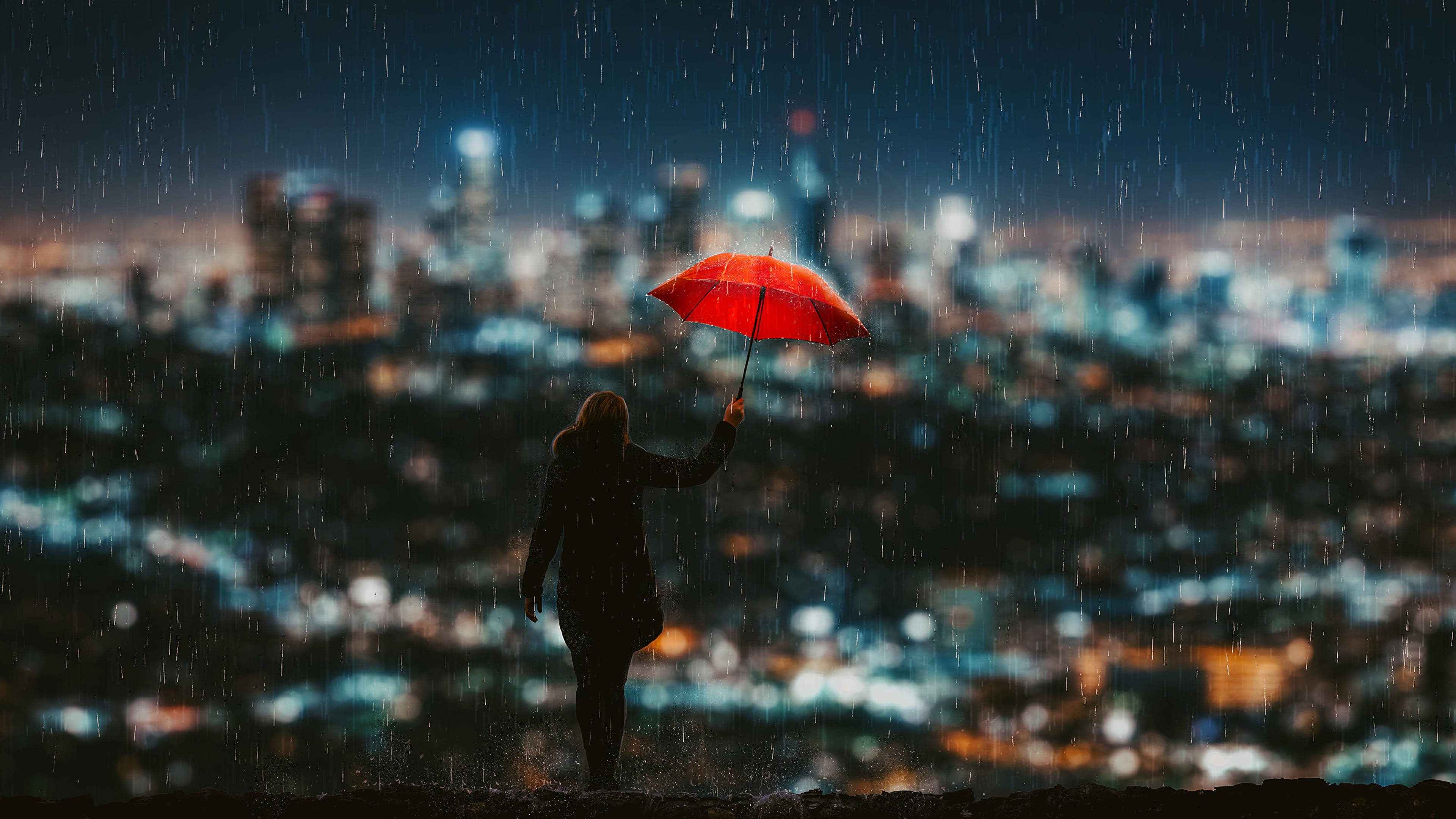 城市 桌布 壁紙 — 一個孤獨的身影在雨中撐著鮮紅色的雨傘，俯瞰夜晚閃爍的城市景觀。