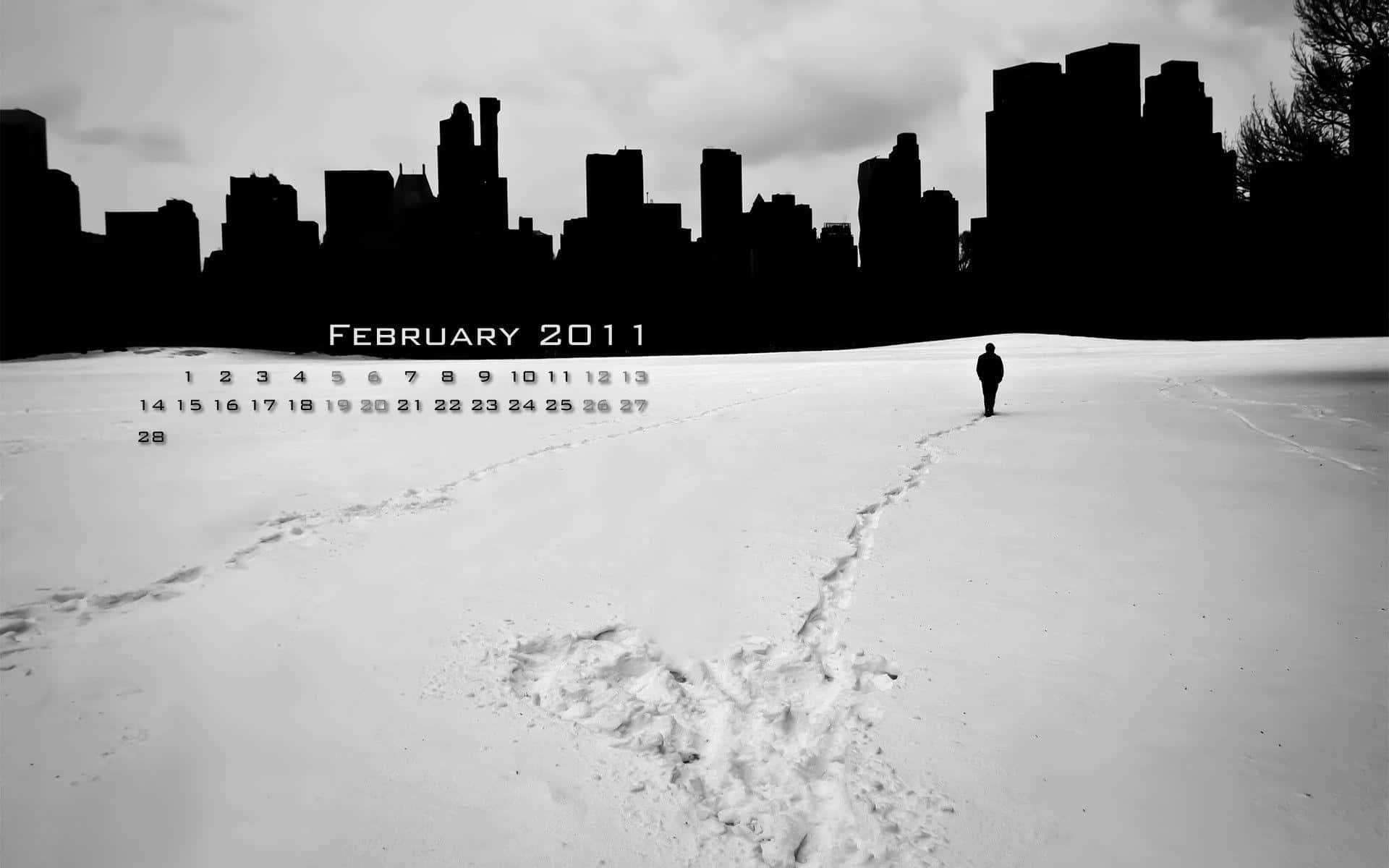 一個人在雪中獨自走向城市天際線，並帶有2011年2月的日曆。 — 二月 GIF 壁紙