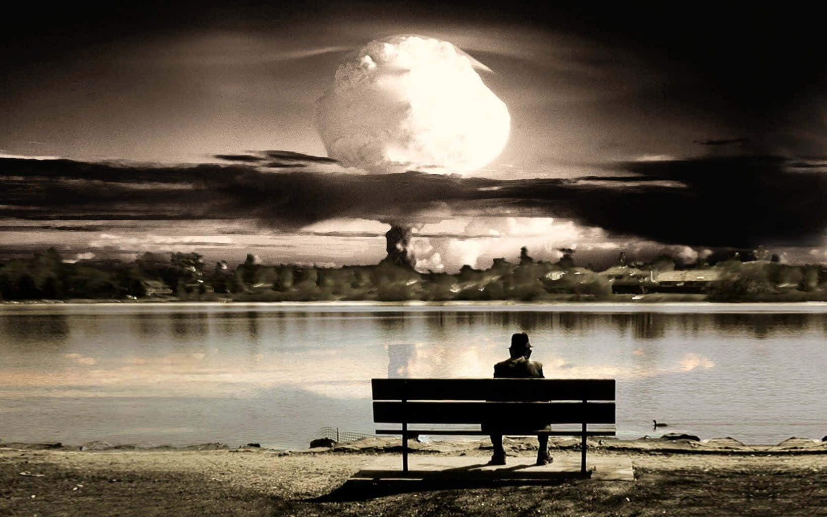 Lonely 桌布 壁紙 — 一個孤獨的身影坐在湖邊的長椅上，背後巨大的核爆炸照亮了黑暗的天空。