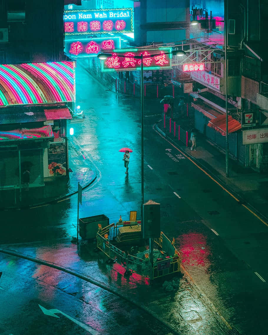 Aesthetic Rain 桌布 壁紙 — 一個孤獨的身影撐著紅色雨傘，在夜晚穿過一條被霓虹燈浸透、雨水浸濕的城市小巷，反射出鮮豔的粉紅色和藍綠色燈光。