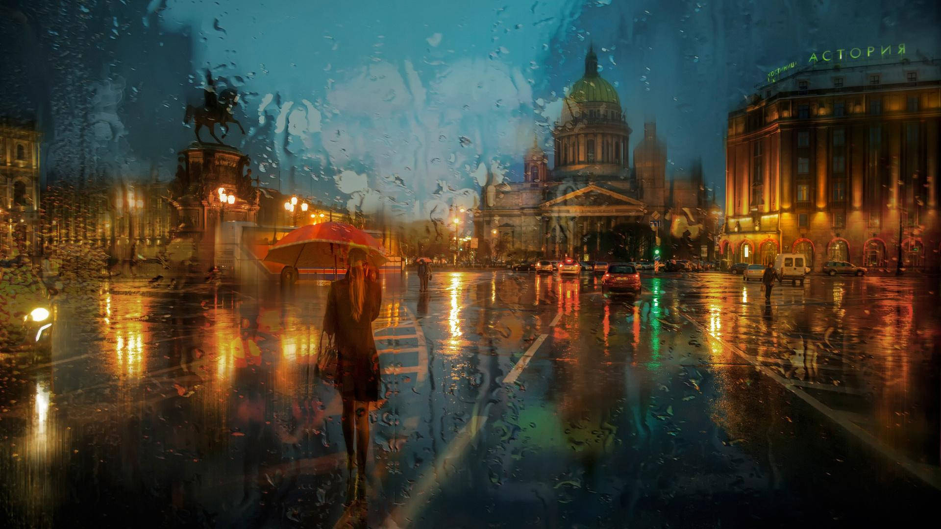 Weather 桌布 壁紙 — 一個孤獨的身影撐著紅色雨傘，在夜晚的雨濕城市街道上行走，被溫暖的路燈照亮，燈光反射在濕漉漉的人行道上。